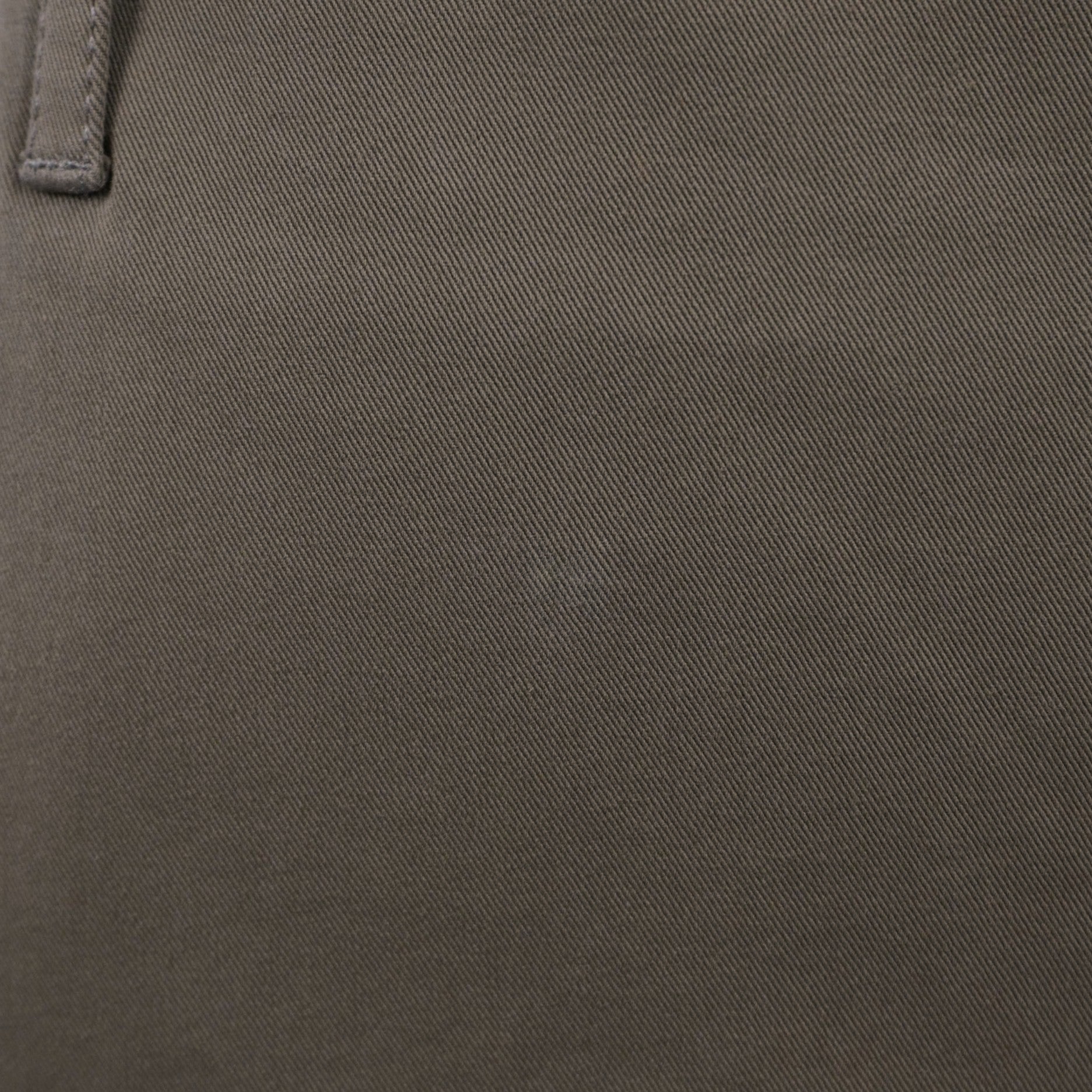 Particolare del tessuto in cotone stretch verde oliva che mostra la trama strutturata ed elasticizzata del capo