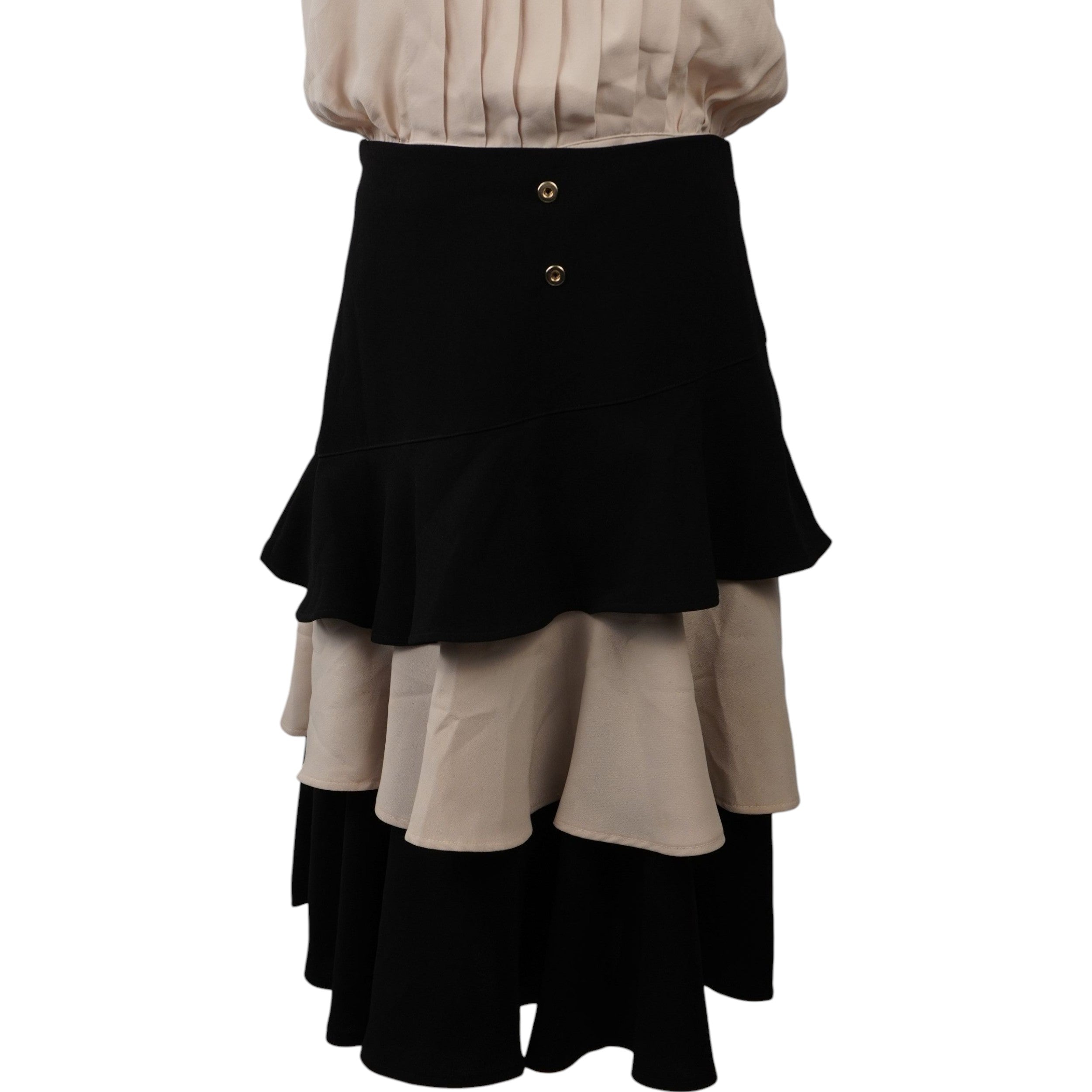 Dettaglio della gonna a balze asimmetriche con bottoni dorati gioiello in vita, design iconico Elisabetta Franchi.