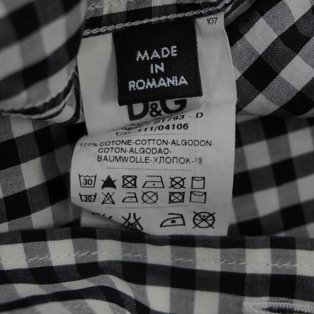 Particolare dell'etichetta interna con composizione 100% cotone, simboli di lavaggio e indicazione Made in Romania.