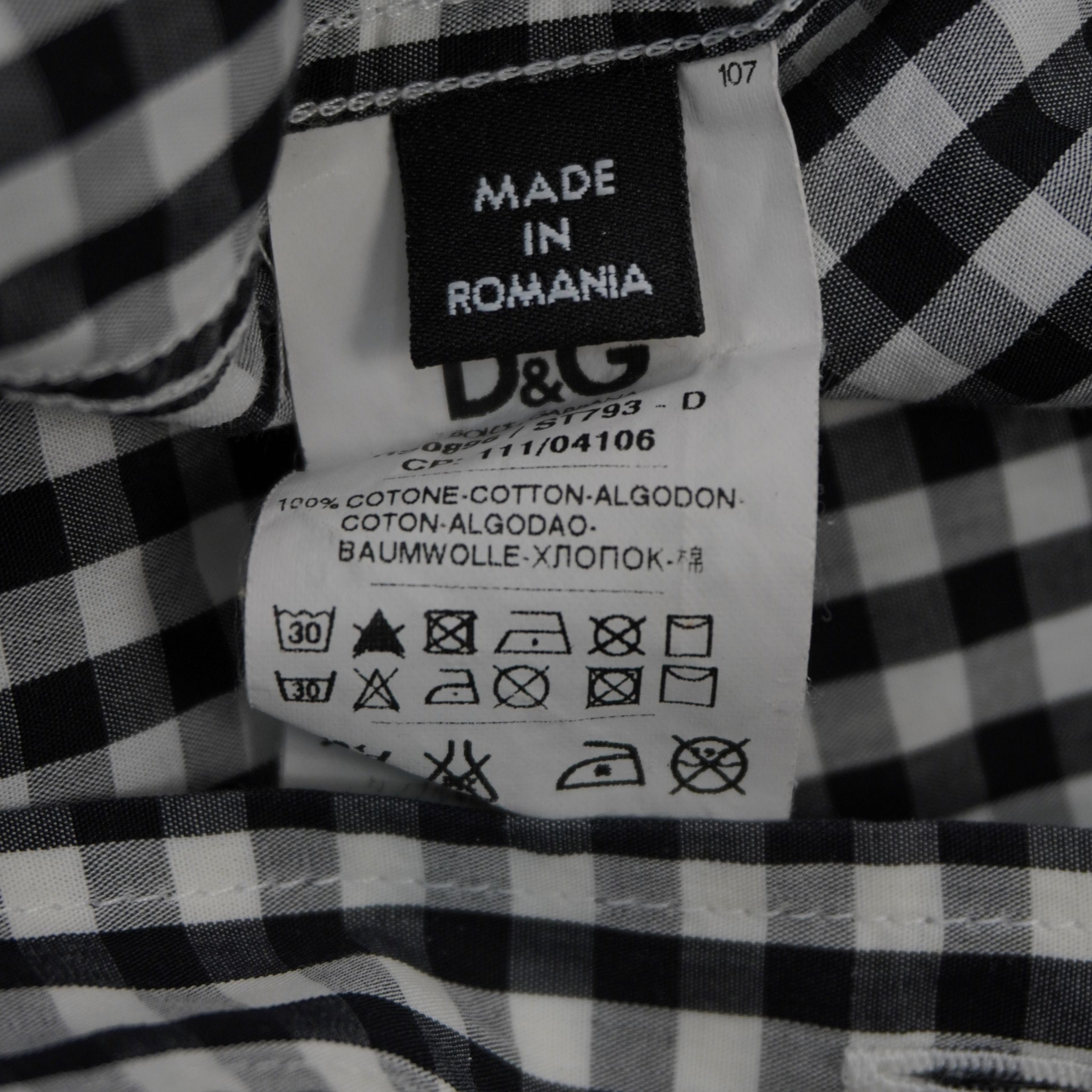 Particolare dell'etichetta interna con composizione 100% cotone, simboli di lavaggio e indicazione Made in Romania.