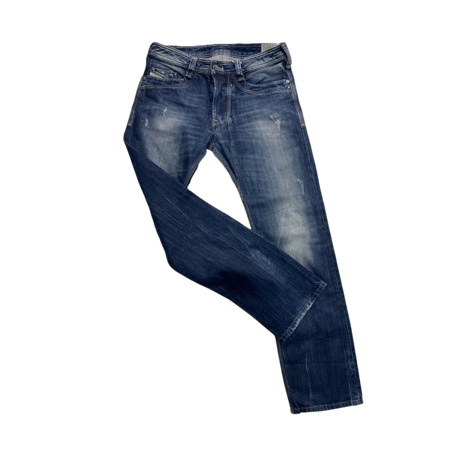 Vista dei jeans Diesel disposti in diagonale che evidenzia l'effetto slavato naturale sulle gambe e sul ginocchio.
