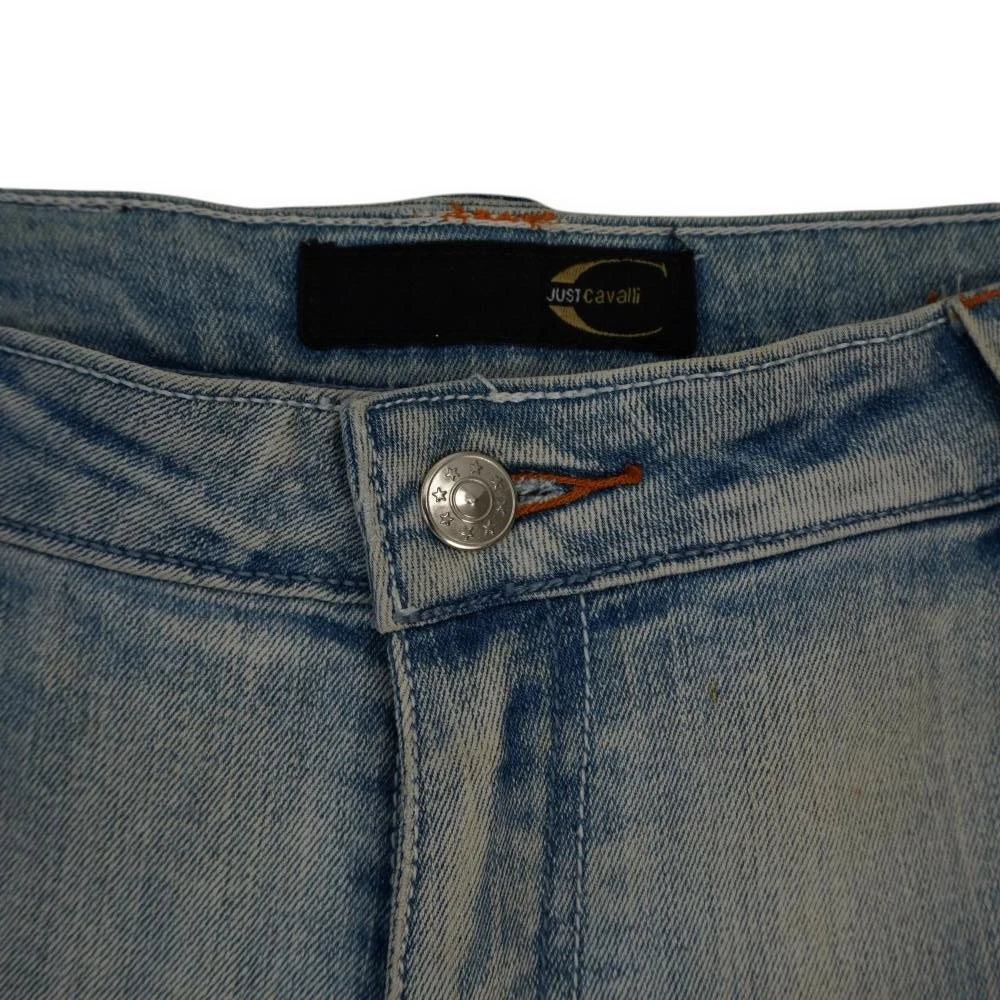 Chiusura centrale del jeans Just Cavalli con etichetta interna nera del brand e bottone metallico con stelle incise.