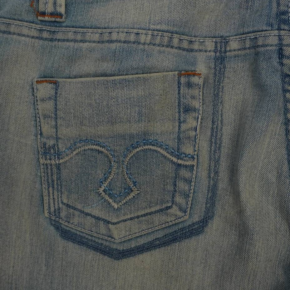 Dettaglio del ricamo ornamentale Snake Wave in filo azzurro lucido sulla tasca posteriore sinistra del jeans Just Cavalli.