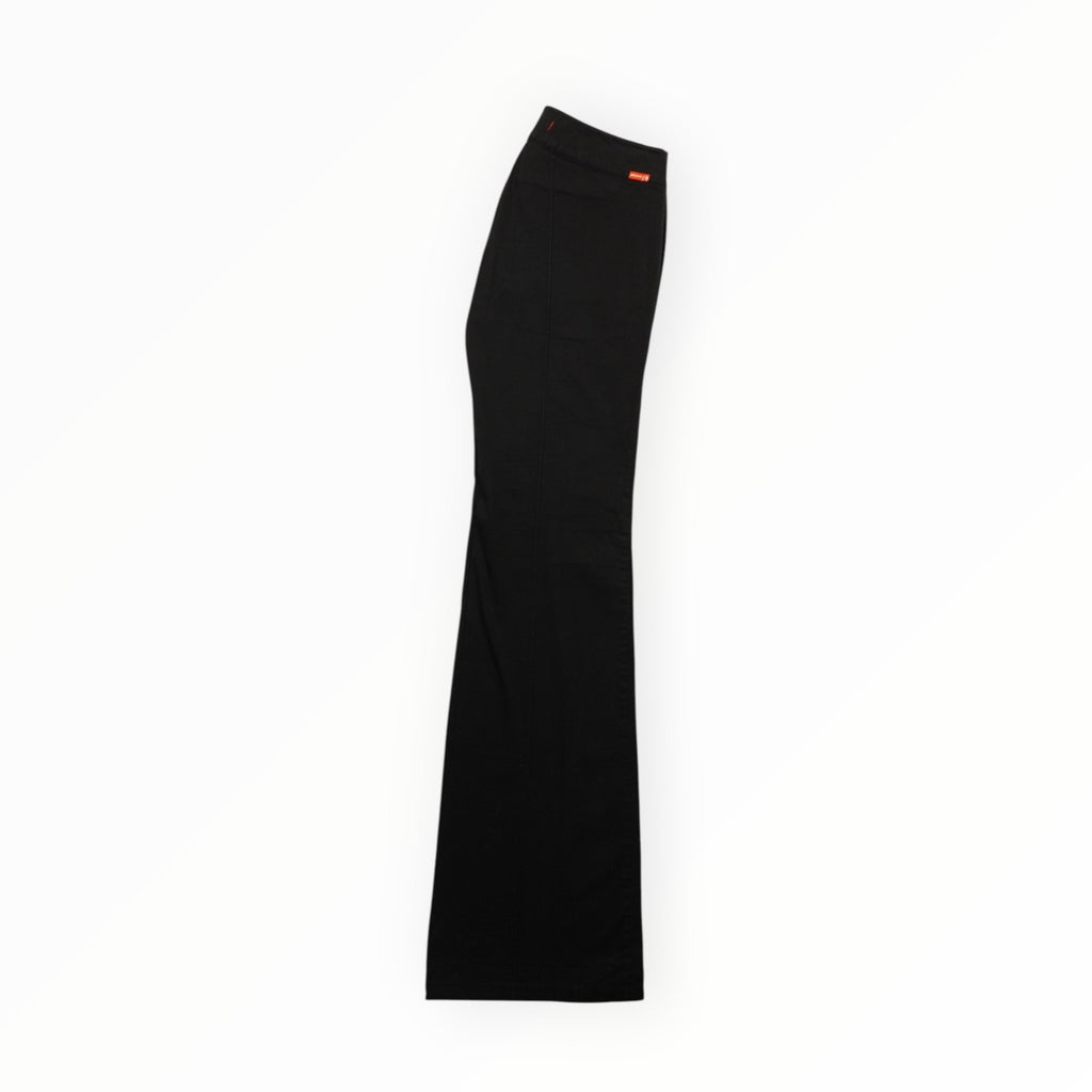Vista laterale della gamba dei pantaloni neri a zampa Phard Jeans che mostra il taglio fluido del tessuto stretch.
