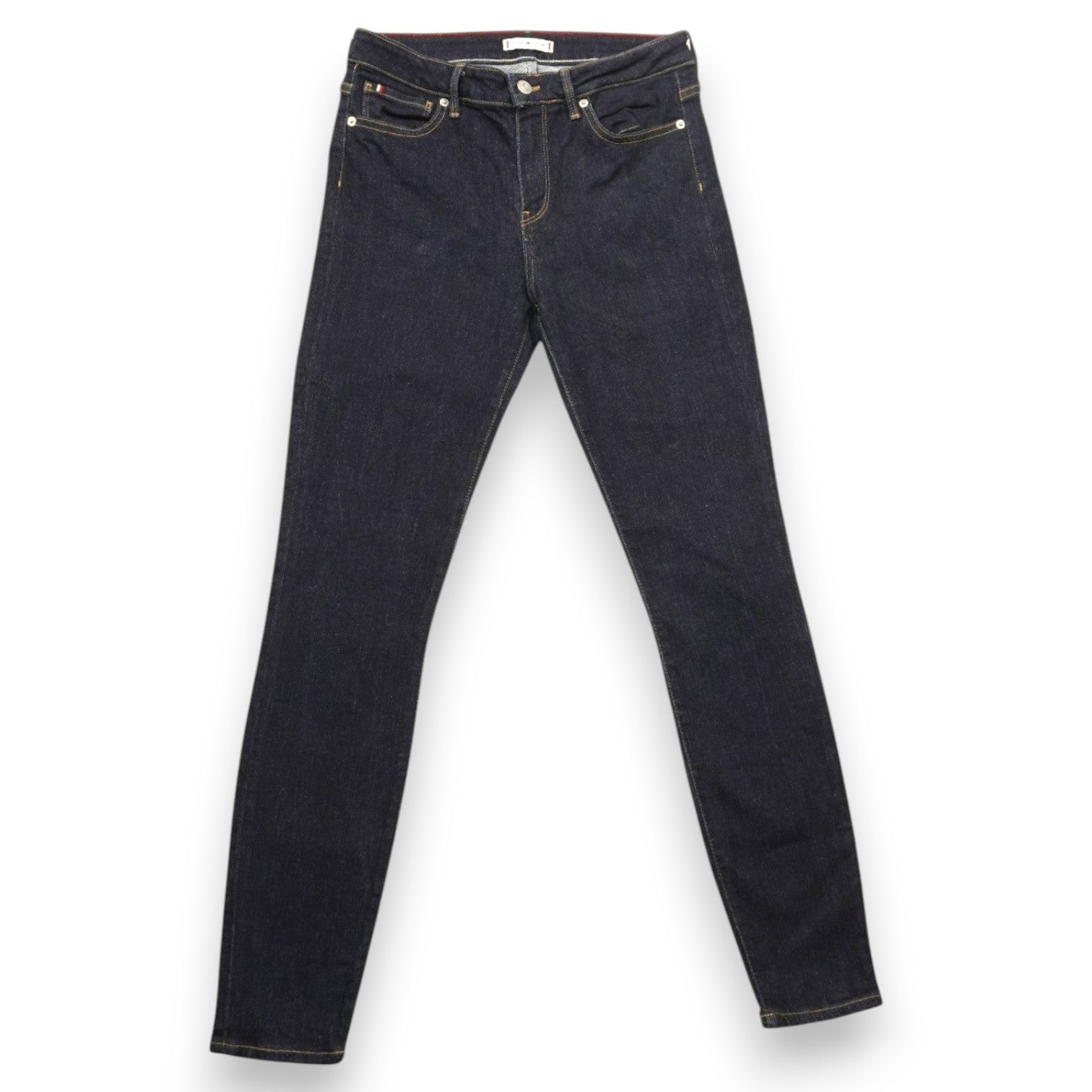 Vista frontale completa dei jeans Tommy Hilfiger skinny stesi, con lavaggio scuro uniforme.
