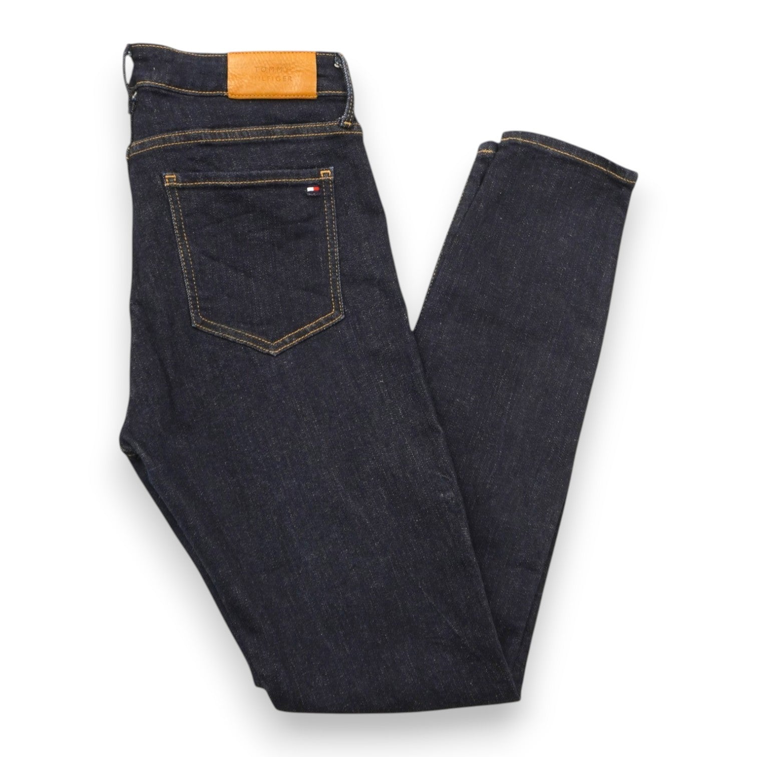  Vista d'insieme di un paio di jeans da donna Tommy Hilfiger in denim scuro Midnight Blue piegati su sfondo bianco.