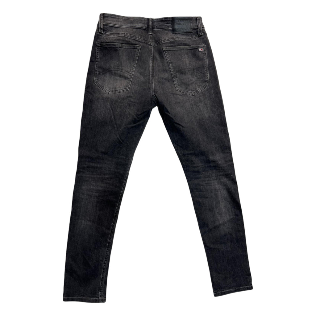 Inquadratura posteriore intera dei jeans grigi distesi, che mostra il taglio skinny aderente e il posizionamento delle tasche sul retro.