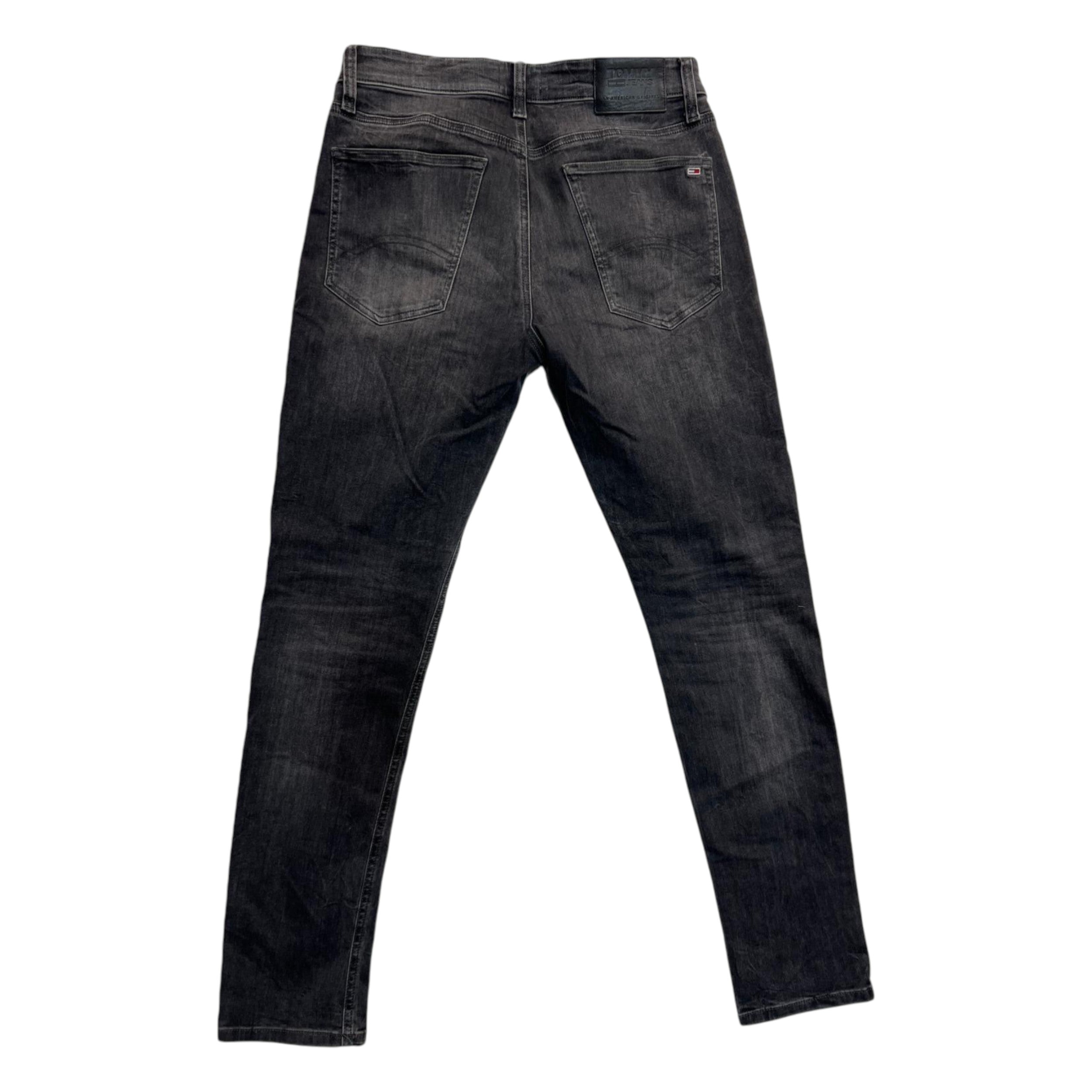Inquadratura posteriore intera dei jeans grigi distesi, che mostra il taglio skinny aderente e il posizionamento delle tasche sul retro.