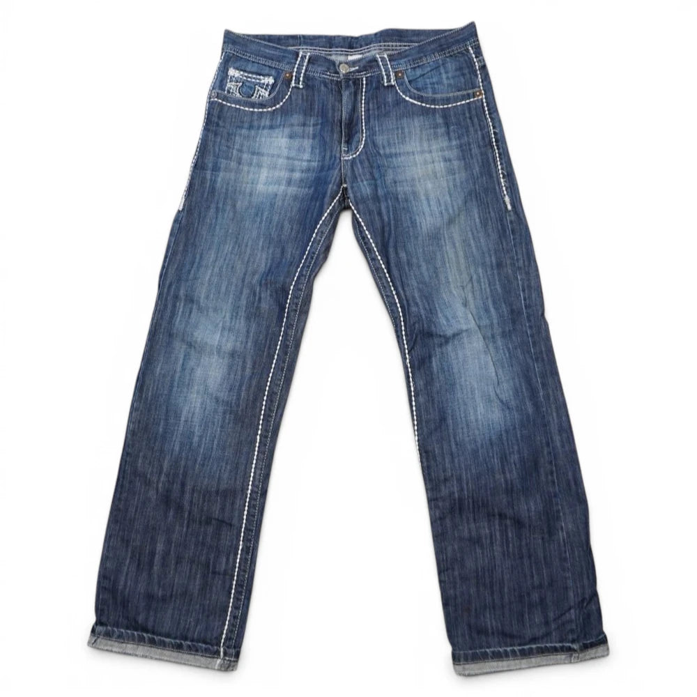 Vista frontale completa su sfondo bianco dei jeans da uomo True Religion in stile Y2K con lavaggio blu medio e spesse cuciture bianche.