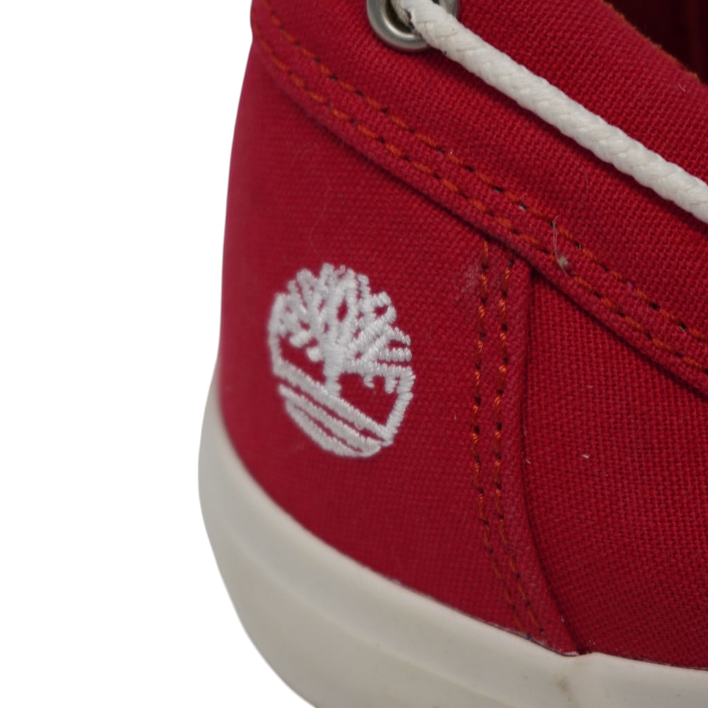 Primo piano del logo ad albero di Timberland ricamato in filo bianco sul tallone laterale rosso.