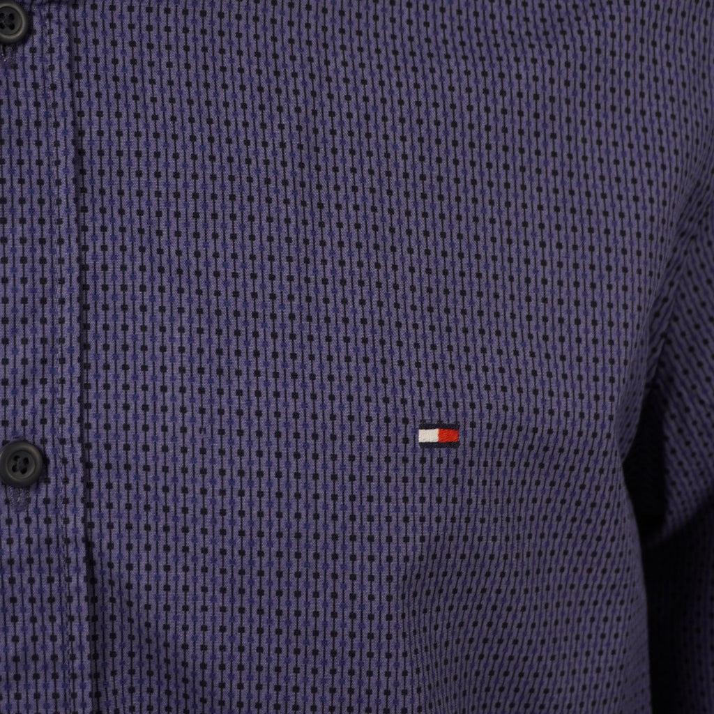Dettaglio macro del mini logo a bandierina Tommy Hilfiger ricamato sul petto della camicia