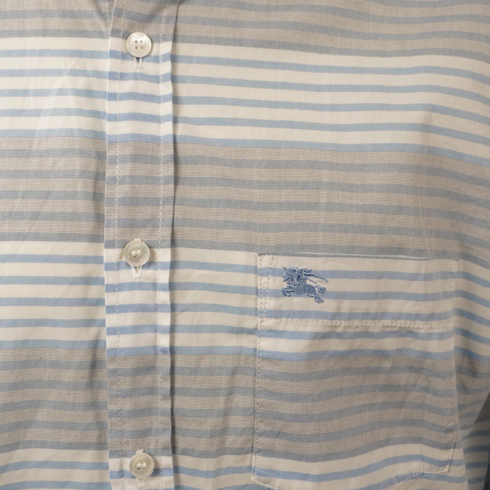 Dettaglio del taschino frontale con logo Burberry Equestrian Knight ricamato azzurro