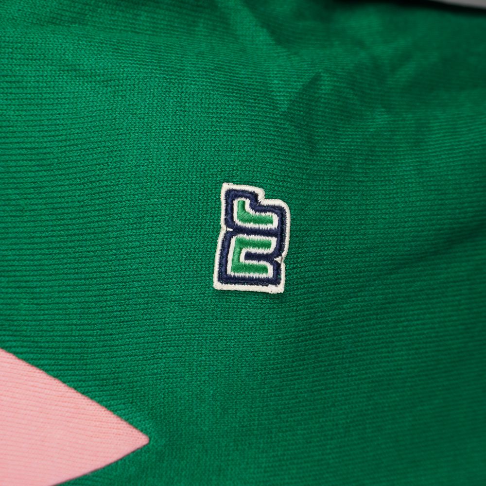 Dettaglio ravvicinato dello storico logo NR Ennerre ricamato in bianco e nero sul petto verde