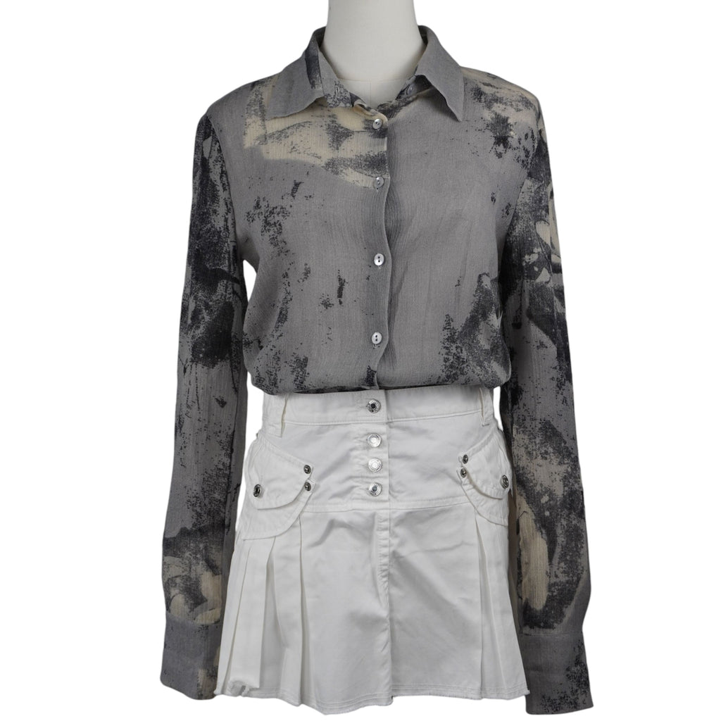  Esempio di outfit: camicetta Class Roberto Cavalli abbinata a una gonna bianca a pieghe, stile contemporary luxury.