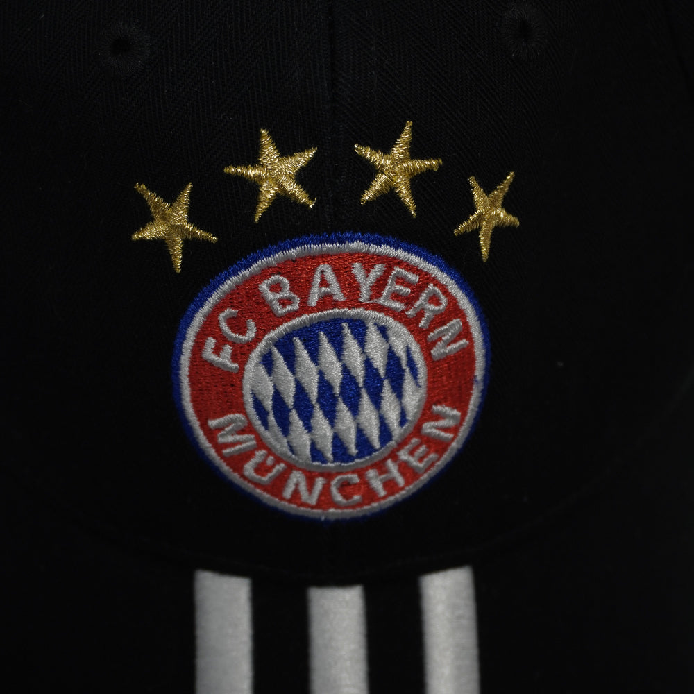 Primo piano del logo ricamato del FC Bayern München sormontato da quattro stelle dorate sul cappellino d'archivio.