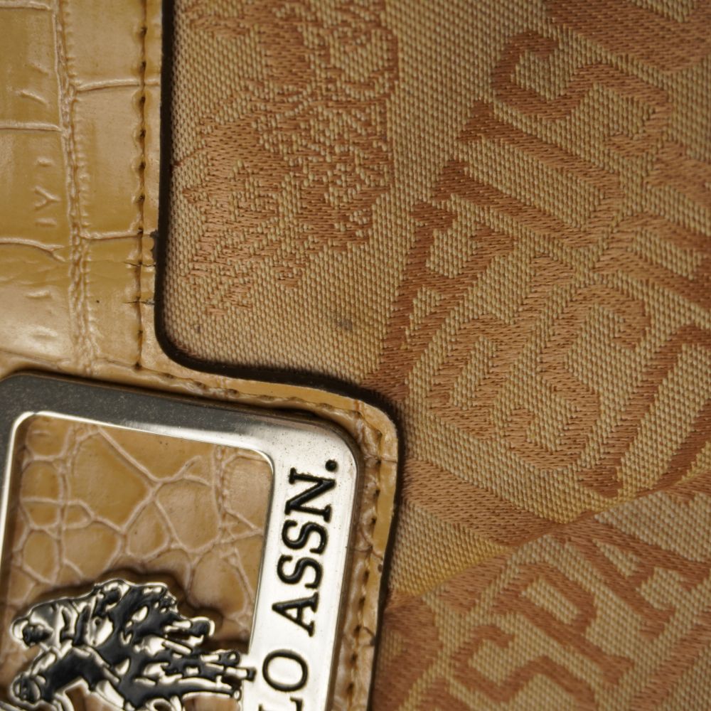 Dettaglio macro della trama del tessuto jacquard beige con monogramma USPA e cuciture sul profilo stampa cocco.