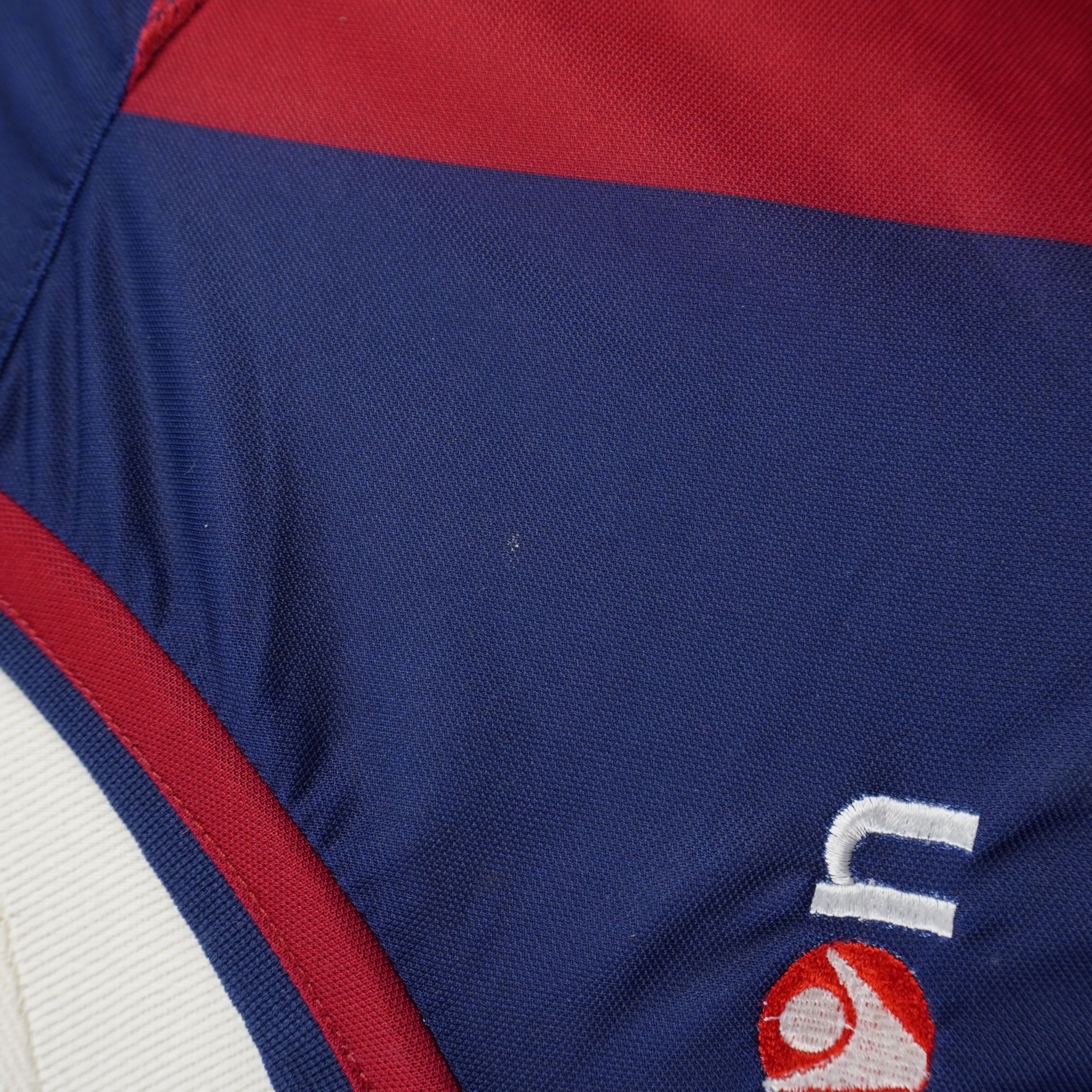 Particolare del colletto a V bicolore rosso e blu della maglia del Bologna con cuciture tecniche elasticizzate