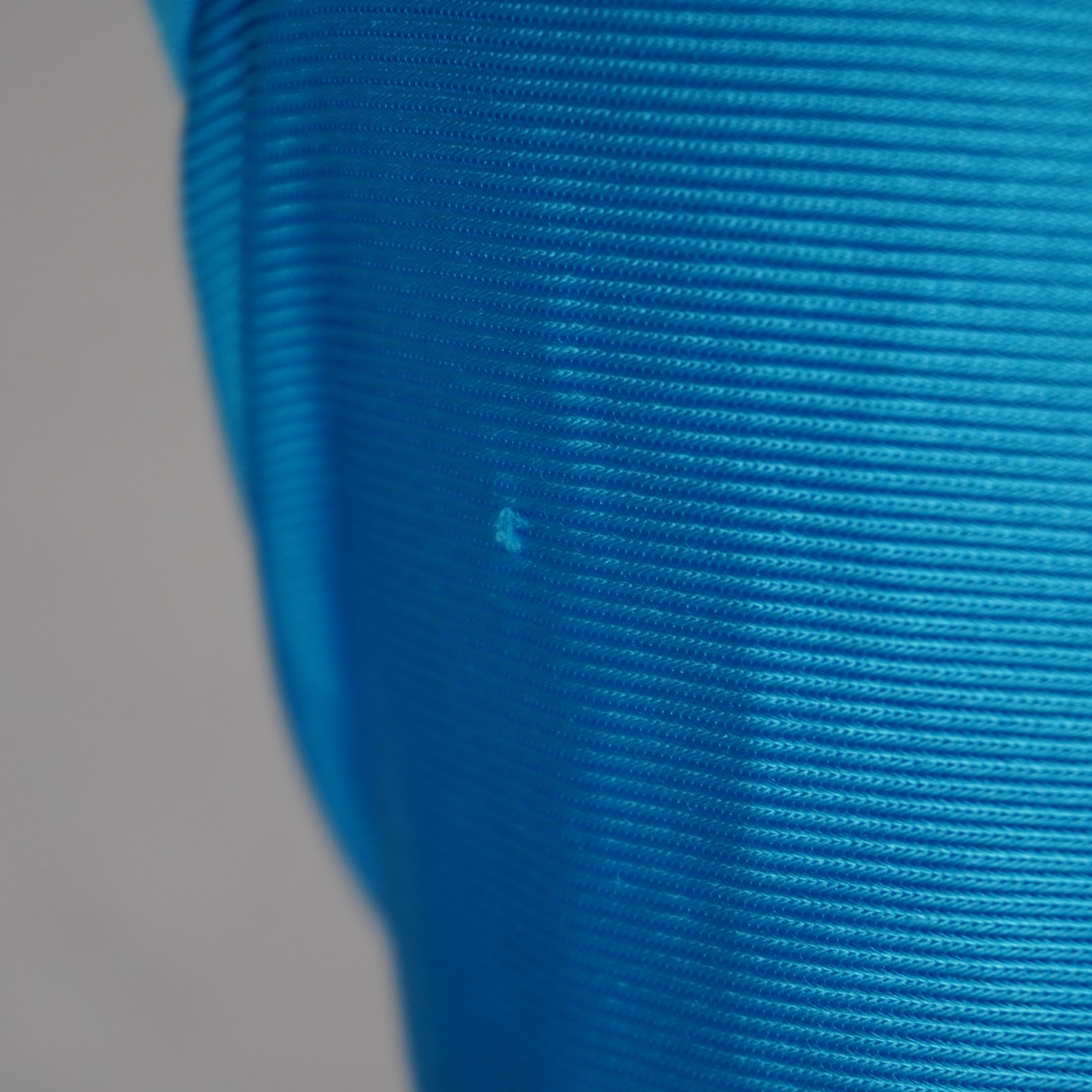 Evidenza del piccolo filo tirato sulla trama del tessuto azzurro segnalato nella descrizione del capo.