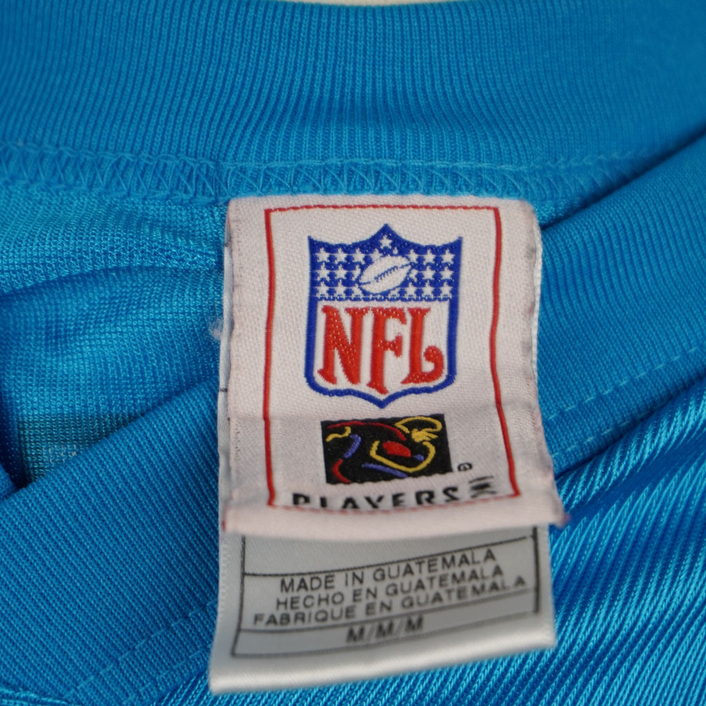 Tag di autenticità NFL Players e brand Reebok applicato sul bordo inferiore esterno della maglia.