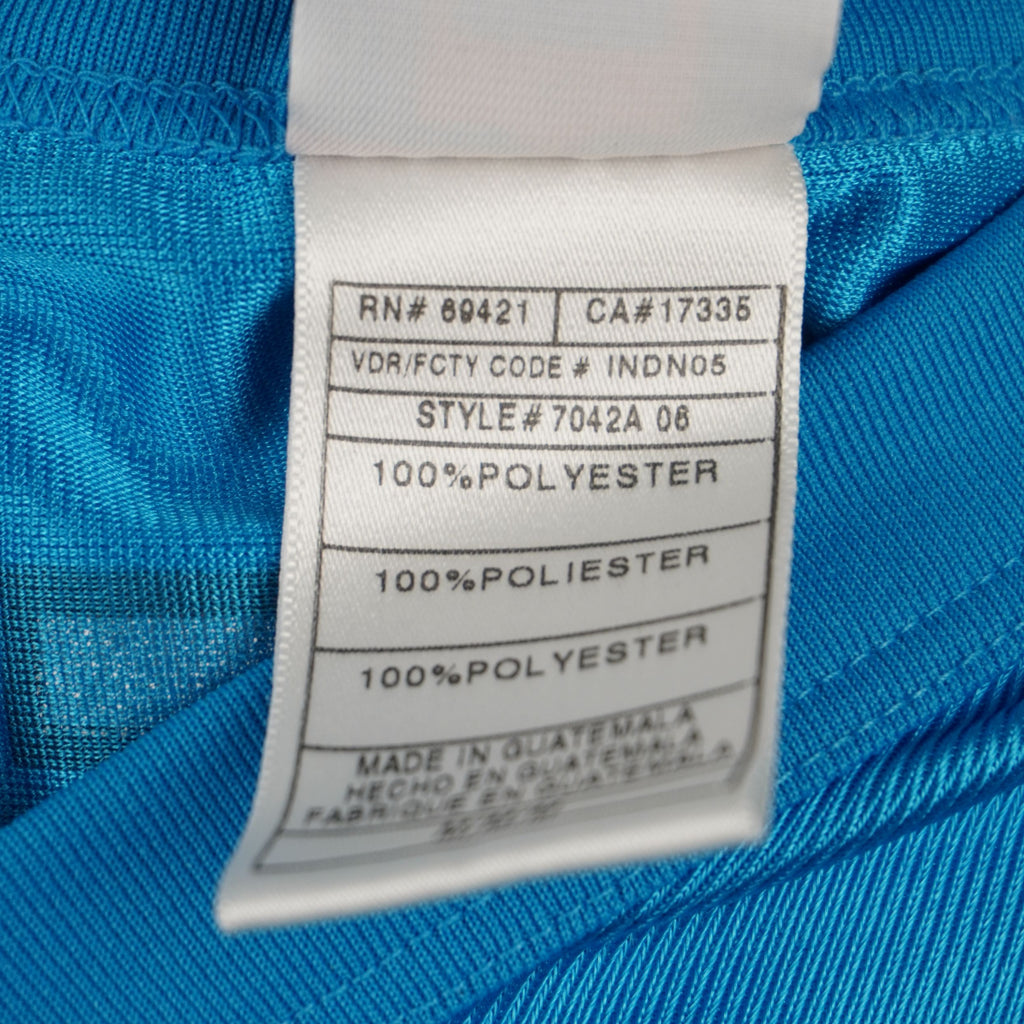 Etichetta interna in tessuto con codice RN69421, Style 7042A e indicazioni di produzione in Guatemala.