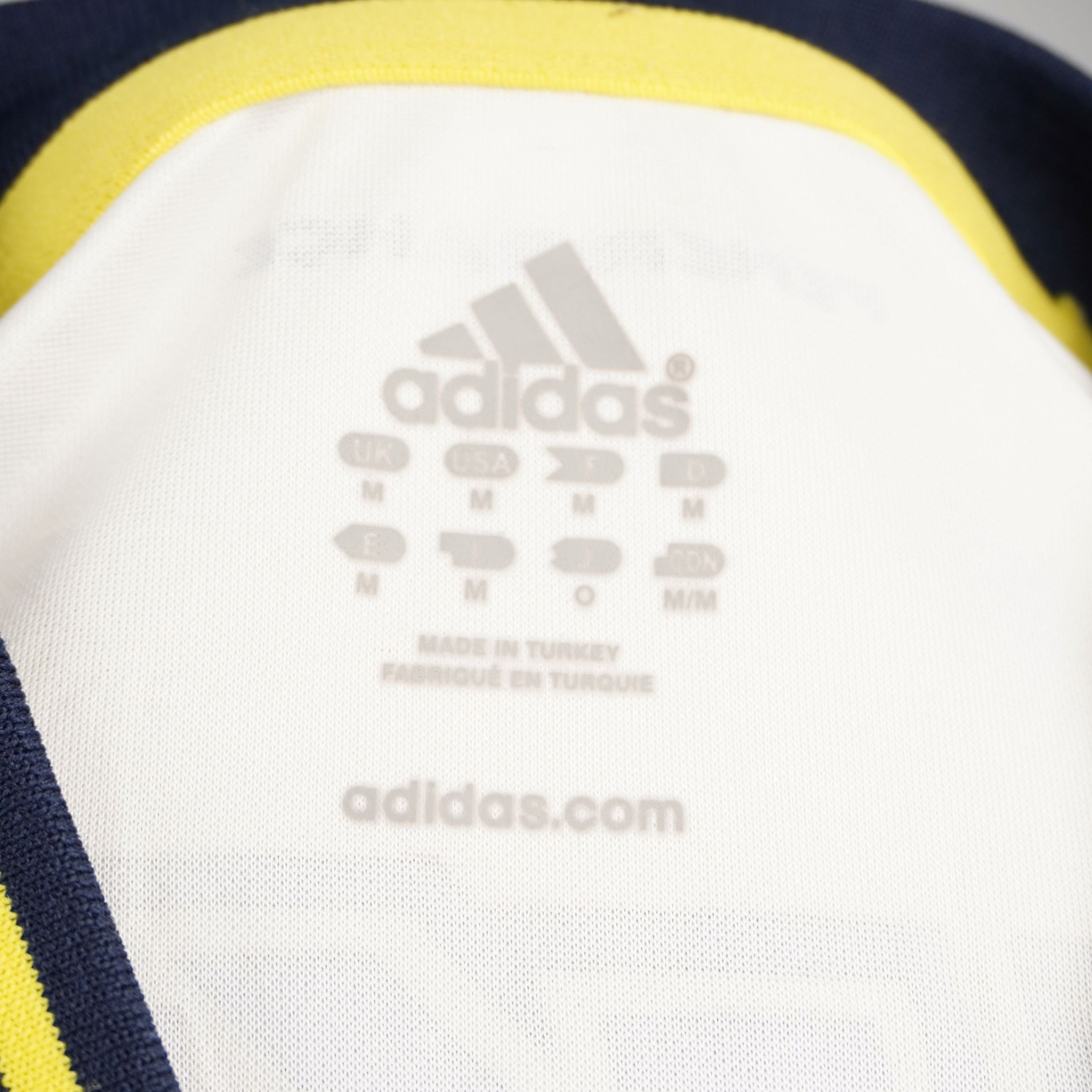 Loghi Adidas e tecnologia Climacool termostampati all'interno del colletto della maglia da calcio.