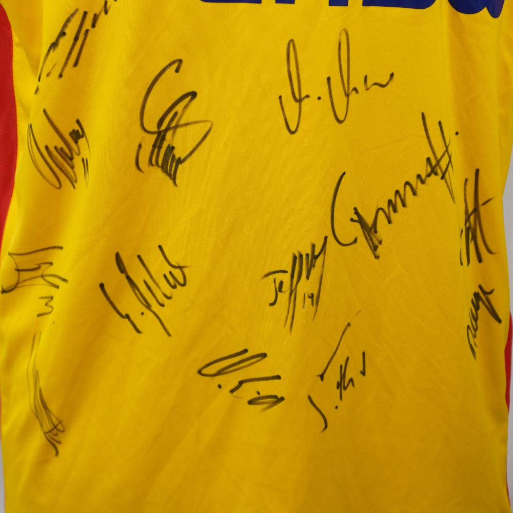 Particolare delle firme autografe della rosa raccolte a mano sul tessuto giallo della maglia.