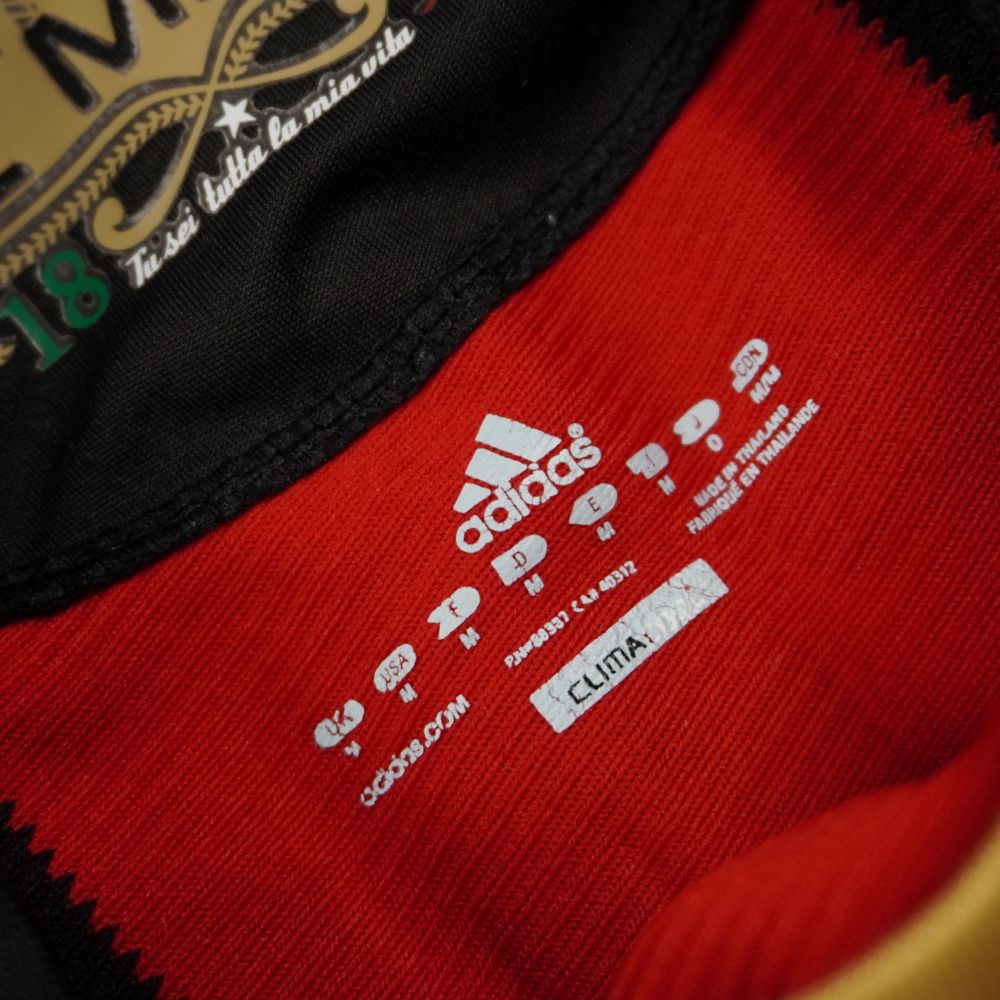 Primo piano delle scritte interne stampate sul tessuto del colletto che indicano la taglia M uomo, la tecnologia Climacool, la manifattura e i codici Adidas.