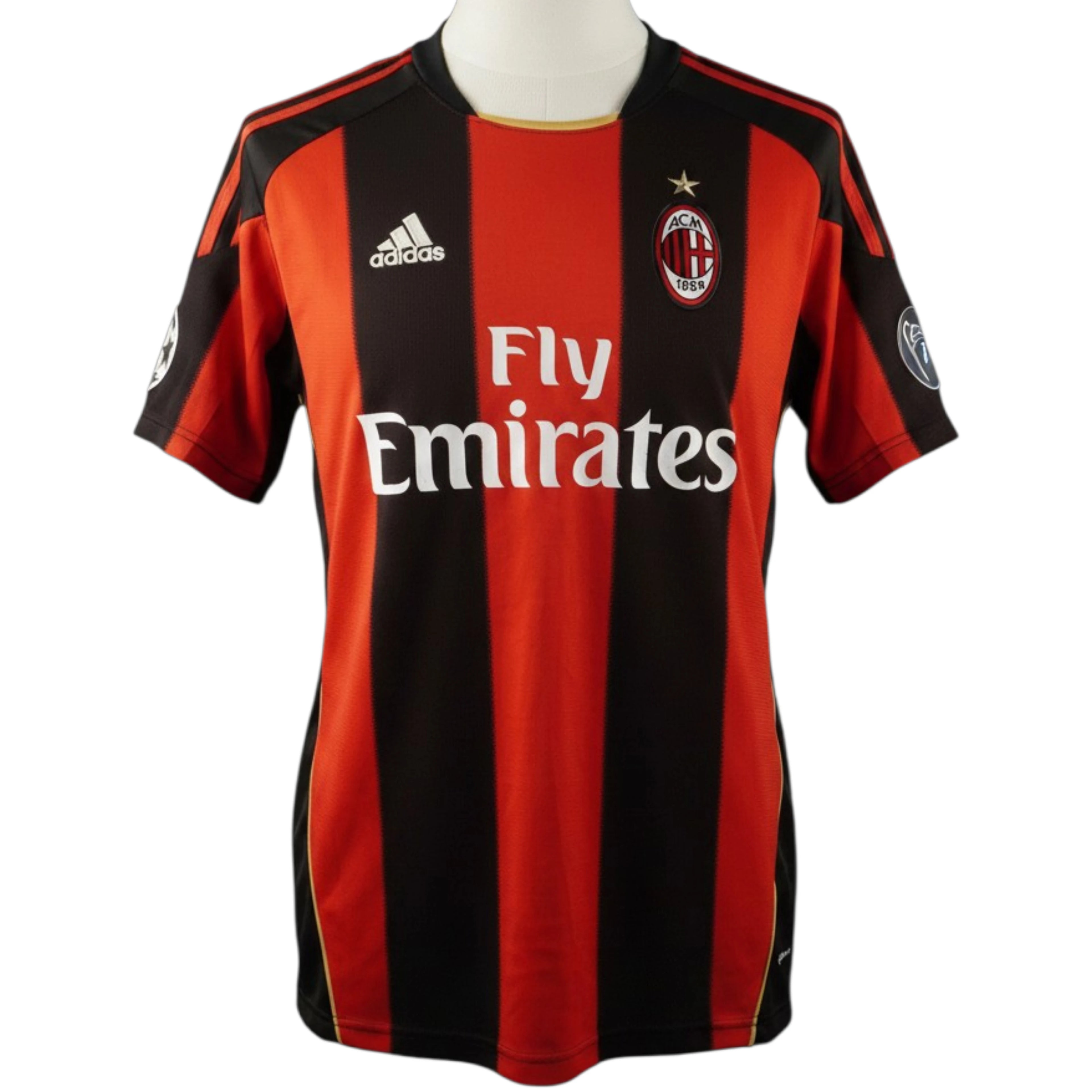 Vista frontale su manichino della maglia da calcio casalinga dell'AC Milan stagione 2011 2012, caratterizzata da strisce verticali rosse e nere strette e sponsor Fly Emirates.
