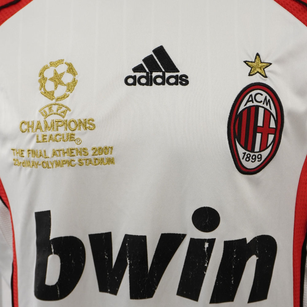 Primo piano del petto della maglia del Milan 2007 con stemma societario, logo Adidas e sponsor bwin.