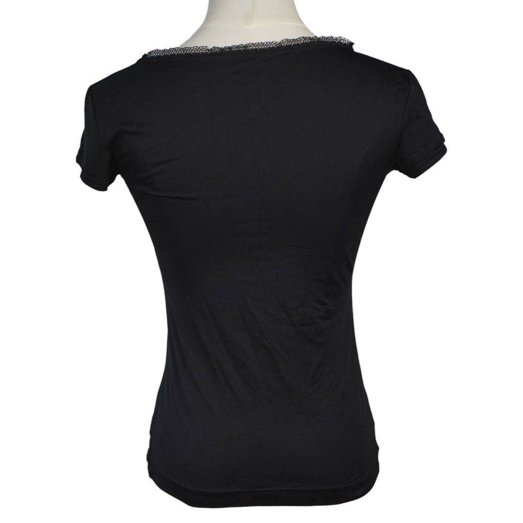 Vista posteriore della t-shirt nera aderente Dolce & Gabbana con scollo sul retro profilato dalla medesima bordatura in pizzo nero ricamato.
