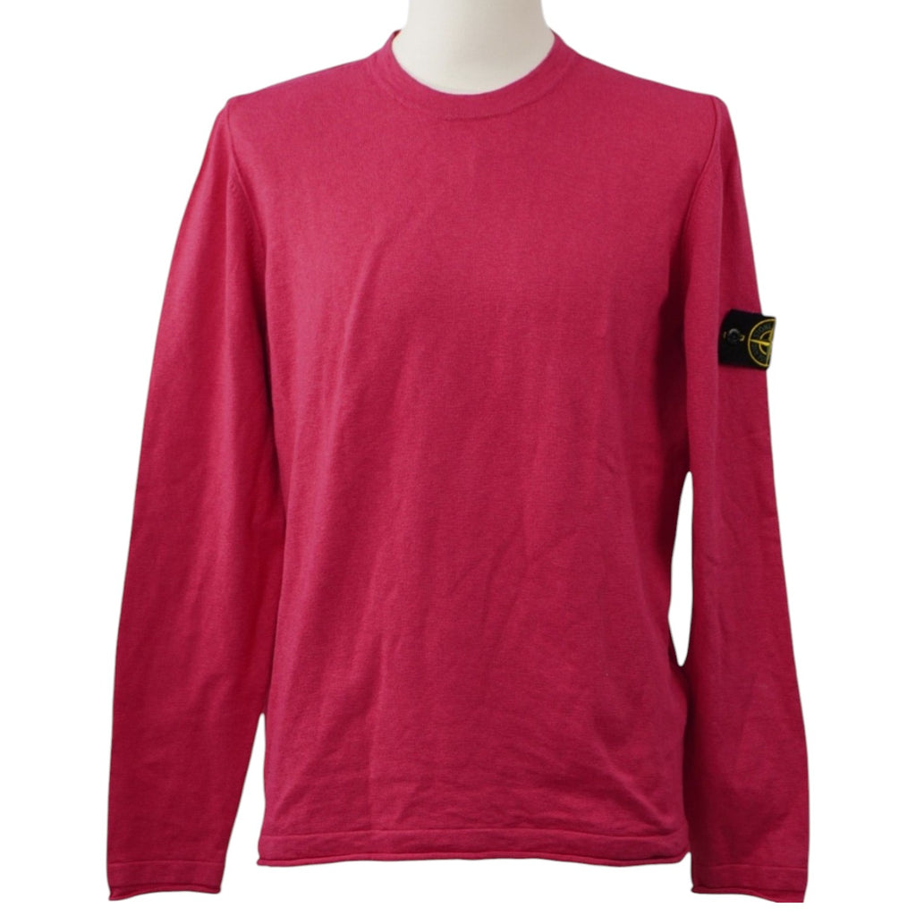 Vista frontale su manichino di un maglione girocollo Stone Island a maniche lunghe color rosa ciclamino con l'iconico badge sulla manica sinistra.