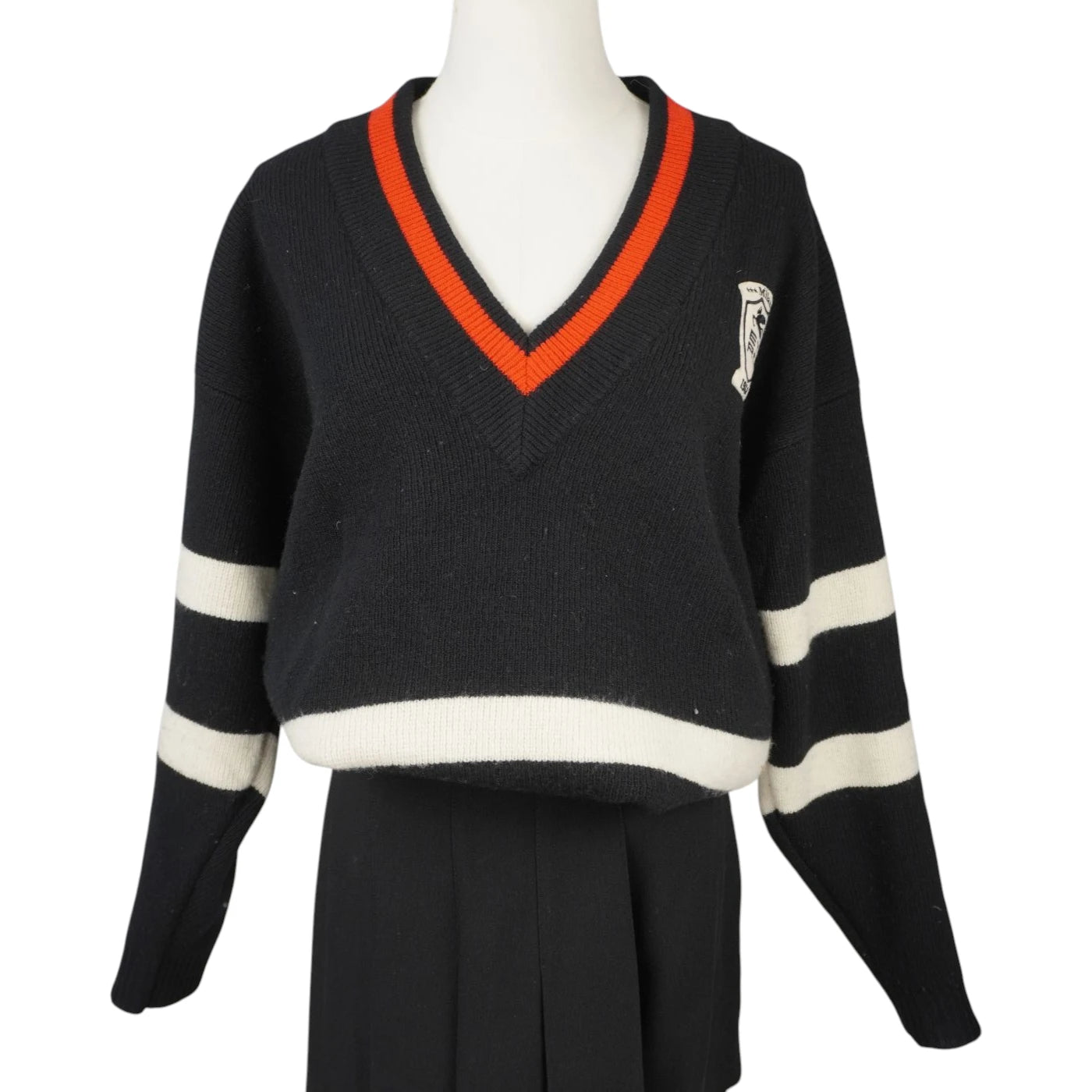 Vista frontale del maglione oversize Etro in lana nera stile college con scollo a V profilato in arancione e bande bianche sulle maniche