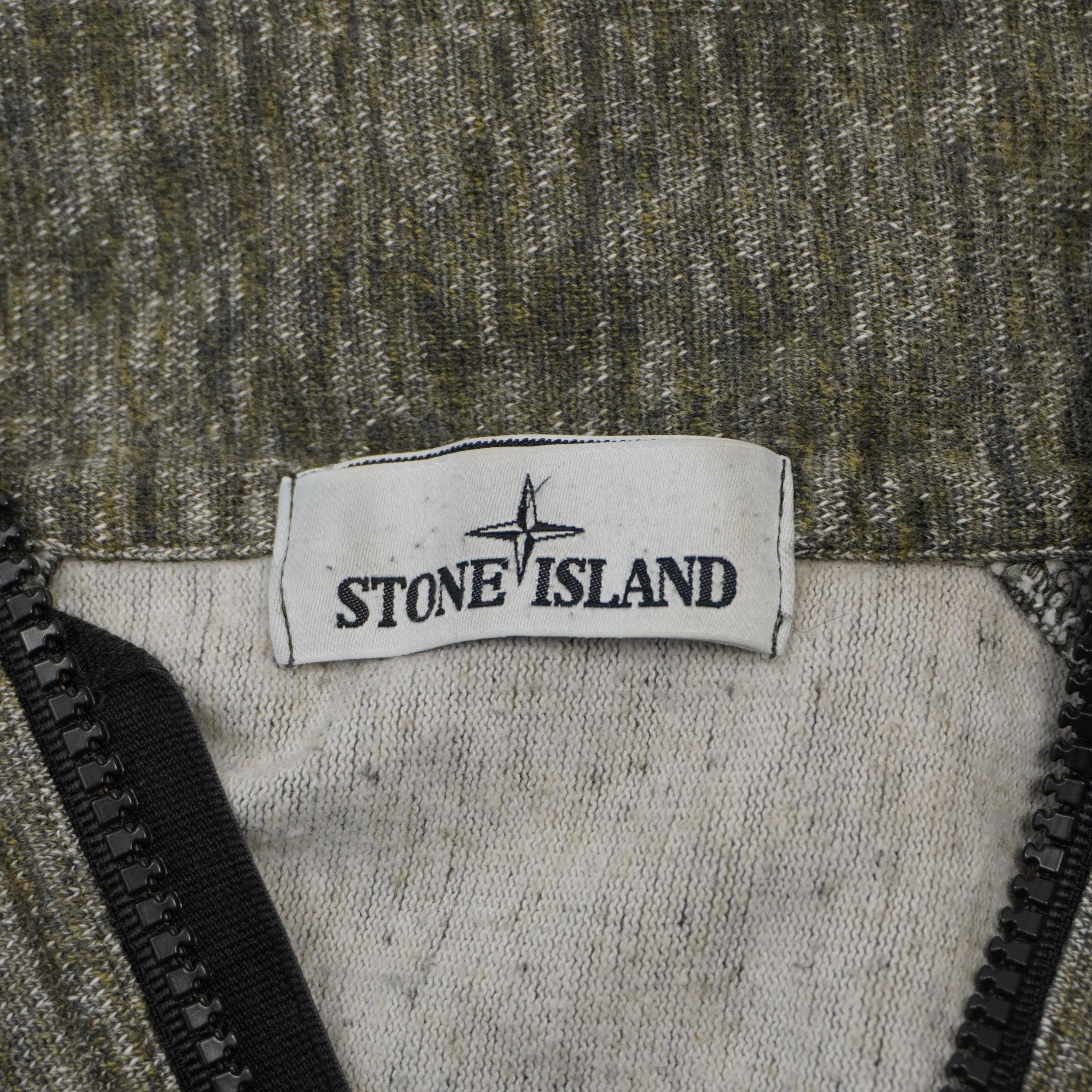 Etichetta bianca istituzionale Stone Island cucita all'interno del colletto a mezza zip.