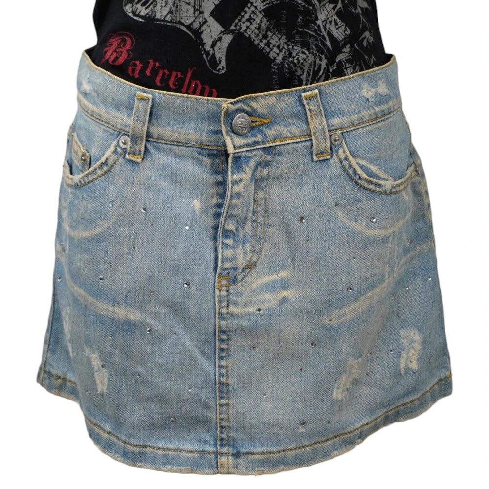 Fronte della minigonna di jeans chiara MEME vintage stile Y2K con strass lucidi e dettagli distressed sul davanti.