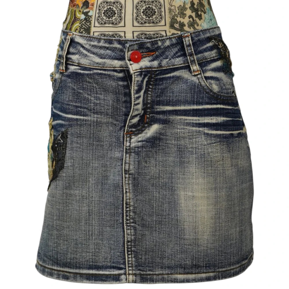 Fronte della minigonna di jeans chiara MISSWAN vintage stile Y2K con lavaggio sabbiato e bottone rosso a contrasto.