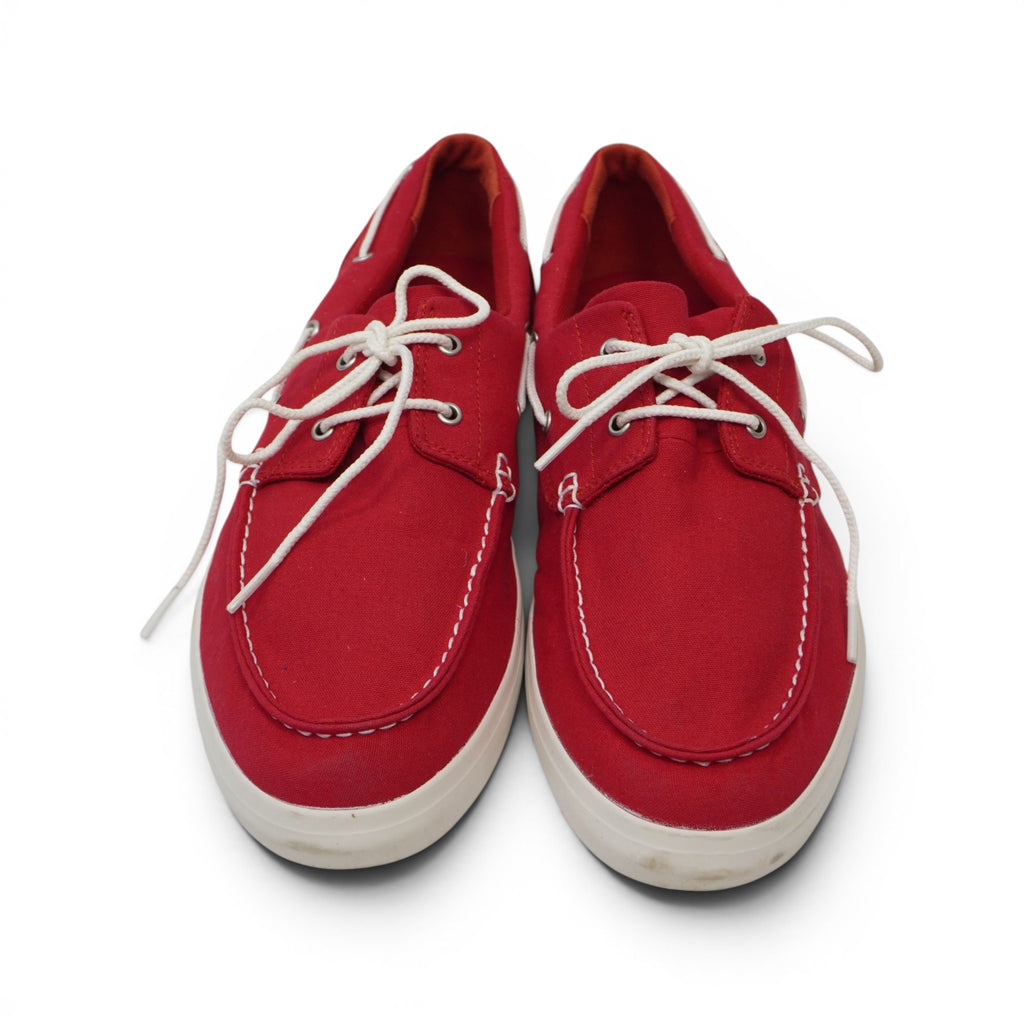 Inquadratura dall'alto del paio di scarpe da barca Timberland in tela rossa pronte per la calzata.
