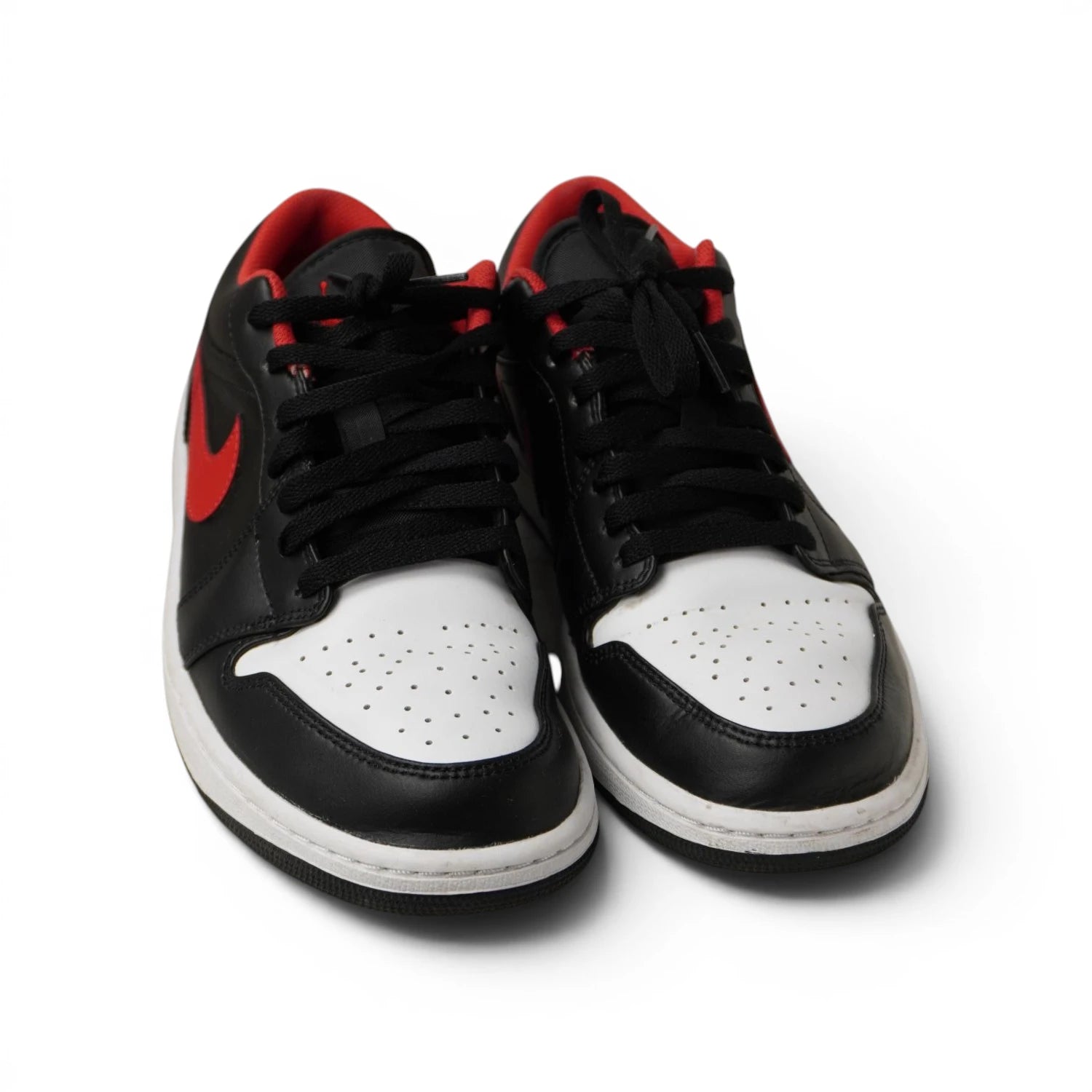 Sneakers Nike Air Jordan 1 Low Black Fire Red White Toe viste di tre quarti su sfondo bianco.