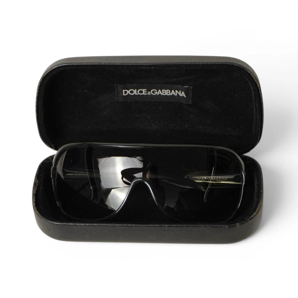 Occhiali da sole a mascherina neri Dolce & Gabbana riposti nella loro custodia rigida originale in velluto nero con etichetta logata