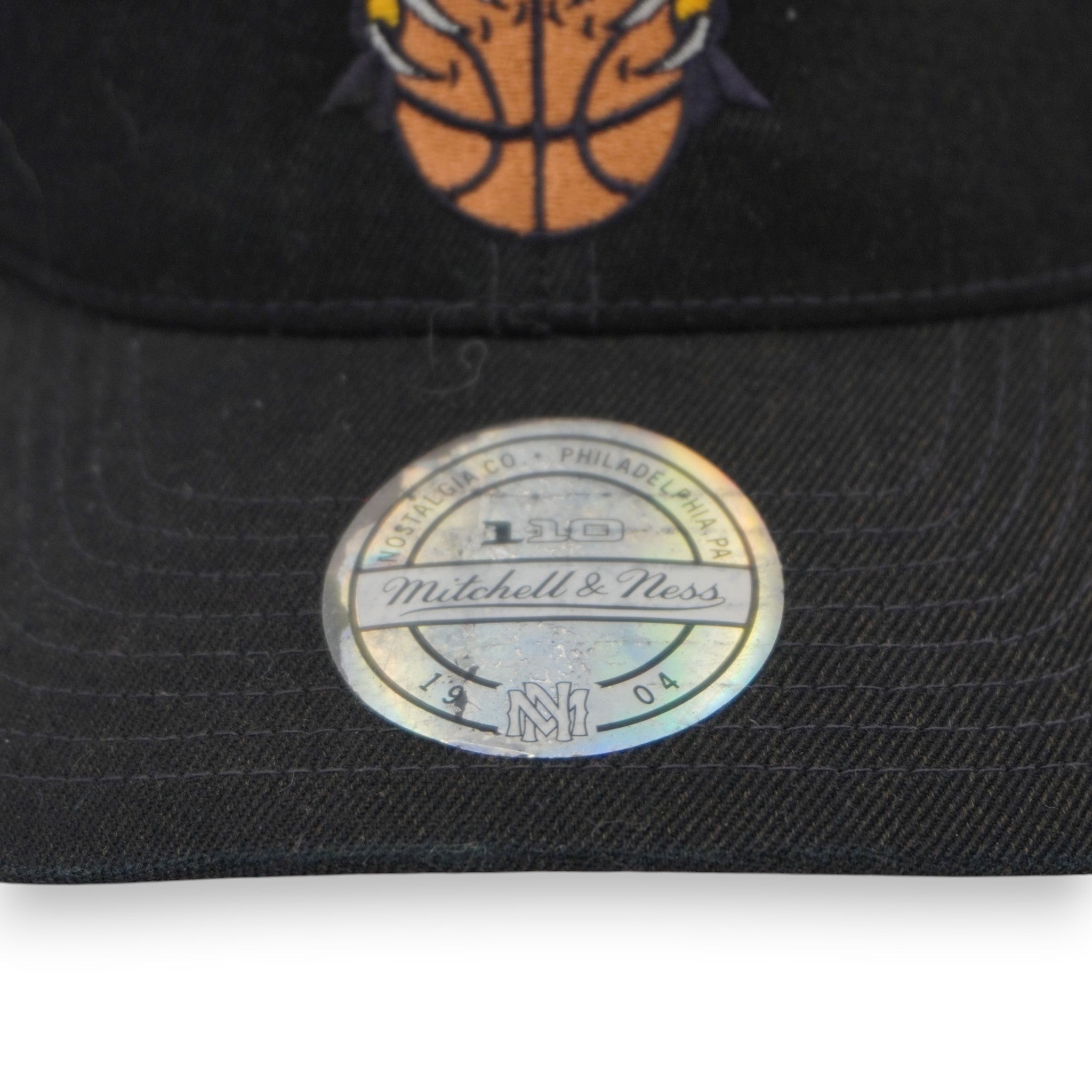 Particolare dell'ologramma ufficiale NBA con codice seriale univoco per certificare l'autenticità del prodotto Mitchell & Ness.