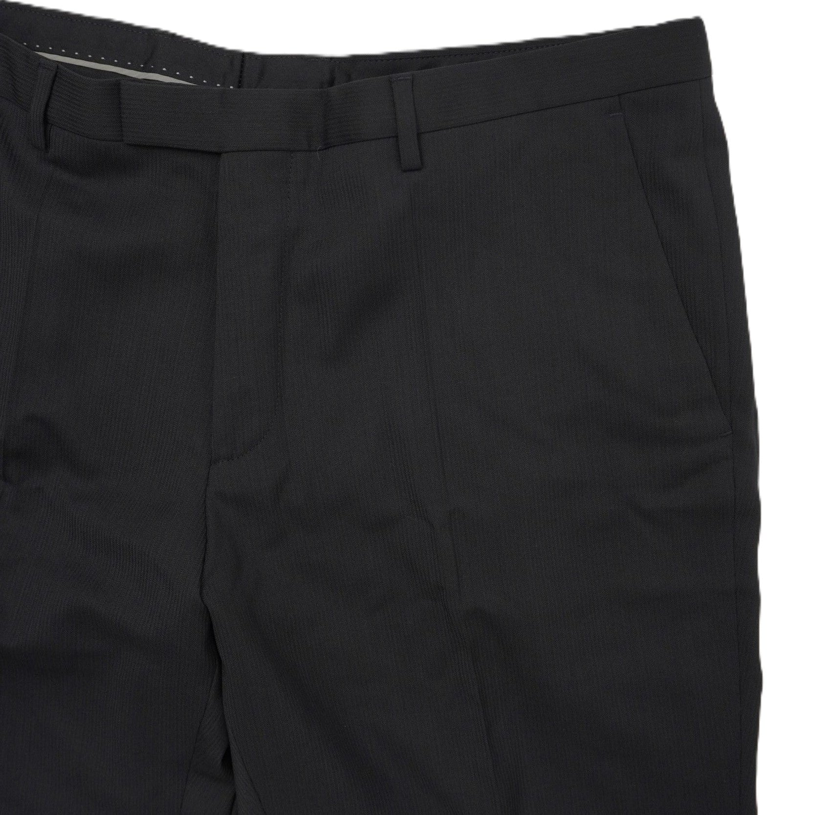 Particolare ravvicinato della zona della vita dei pantaloni neri con la chiusura a gancio a scomparsa e passanti per cintura.