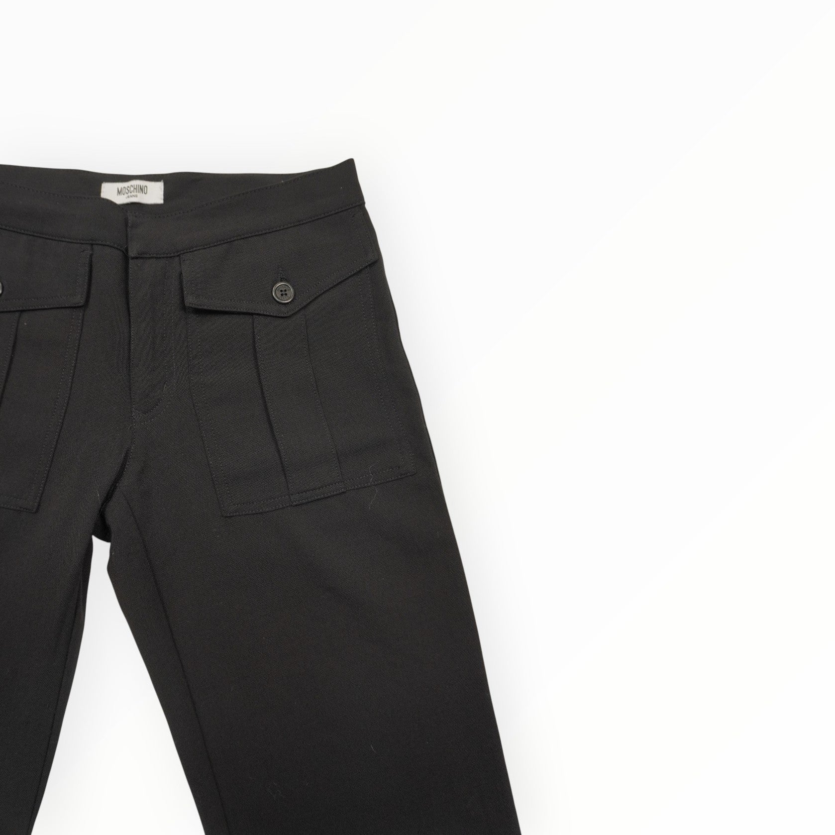  Inquadratura ravvicinata del girovita frontale dei pantaloni Moschino Jeans con le tasche applicate.