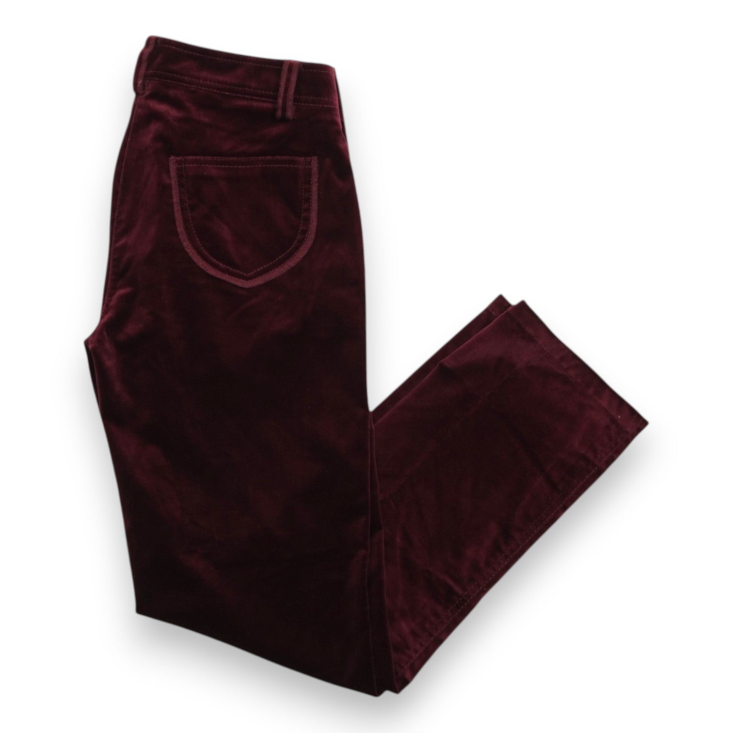 Vista d'ensemble dall'alto di un paio di pantaloni in velluto liscio bordeaux Luisa Spagnoli stesi su sfondo bianco.