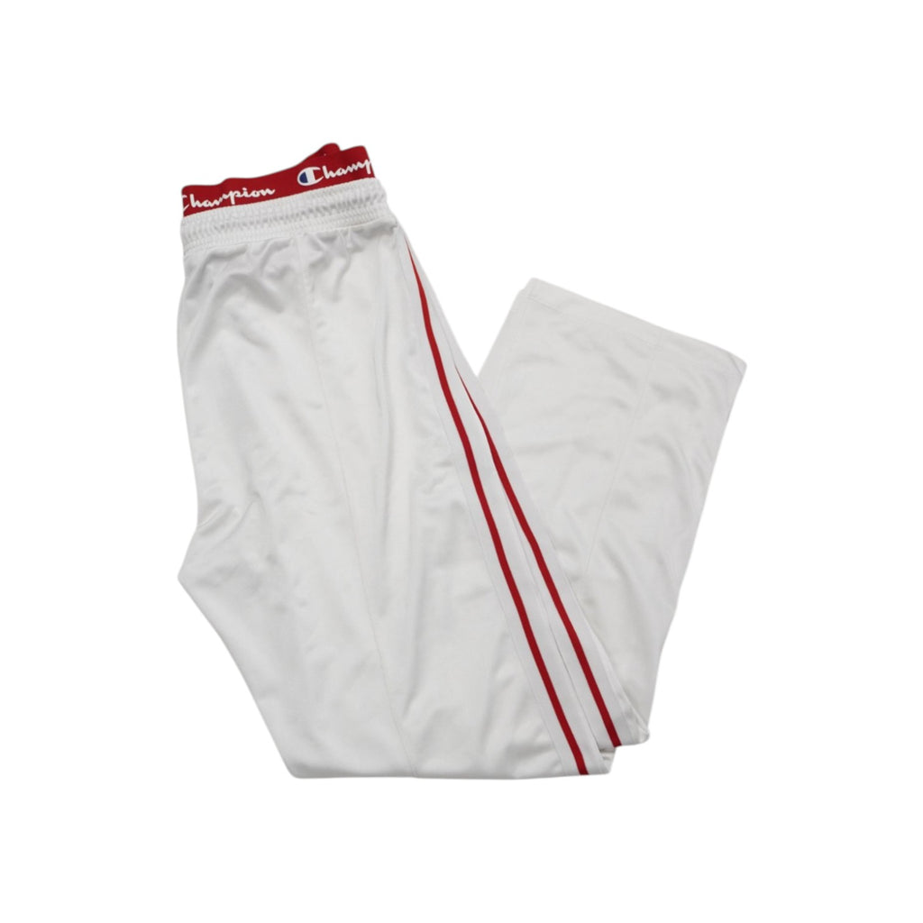 Pantaloni sportivi Champion bianchi piegati, con profili rossi laterali e iconica banda elastica rossa logata in vita.