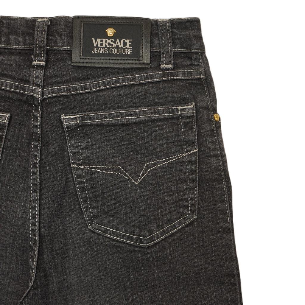 Inquadratura ravvicinata della parte posteriore della vita con le due tasche e la patch istituzionale nera Versace Jeans Couture.