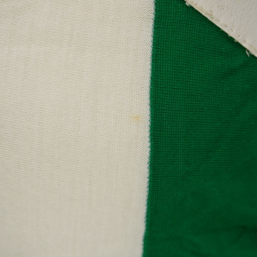  Inquadratura della linea di cucitura tra tessuto bianco e verde sul retro della maglia Diadora