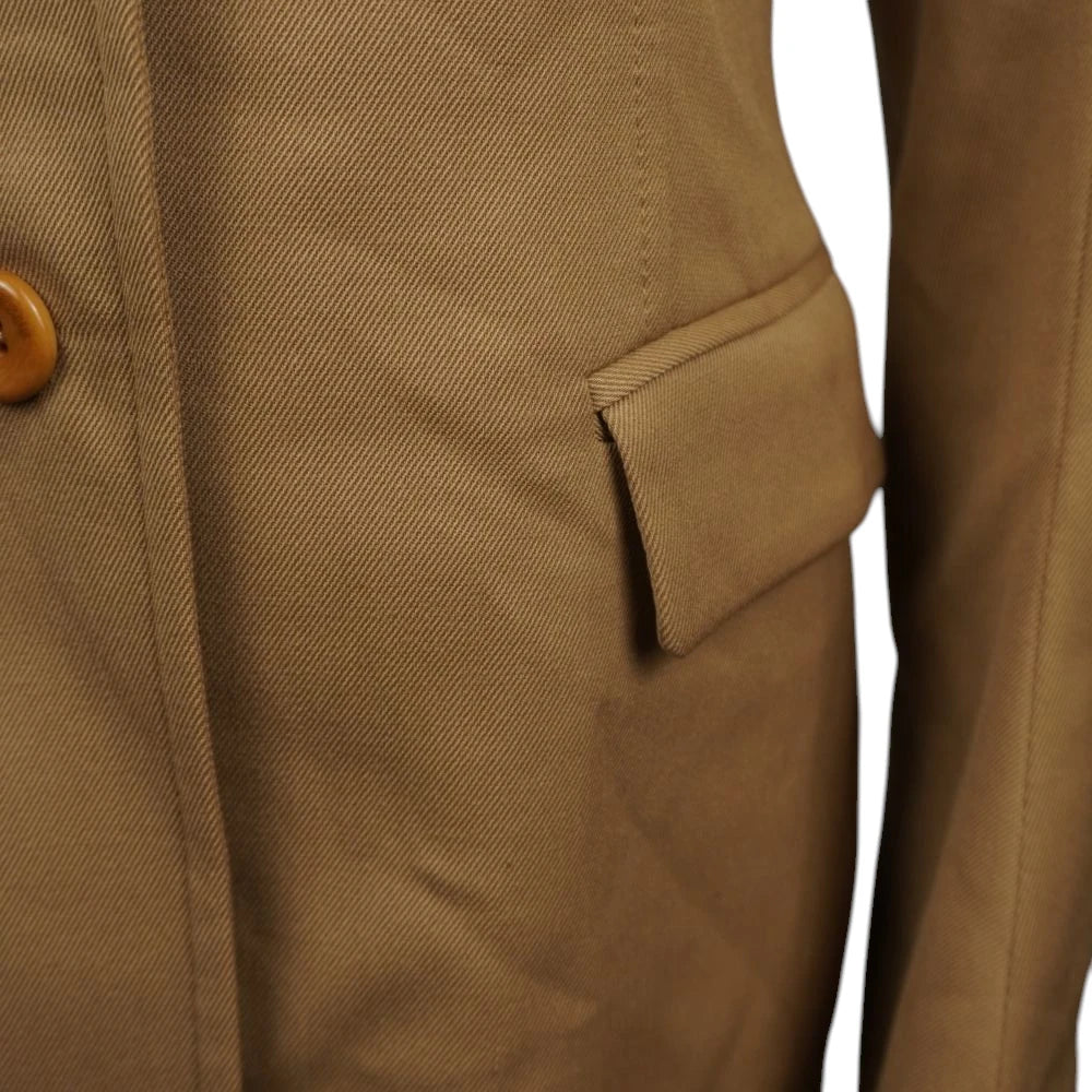 Particolare ravvicinato della tasca laterale con patta del blazer Versus color cammello.