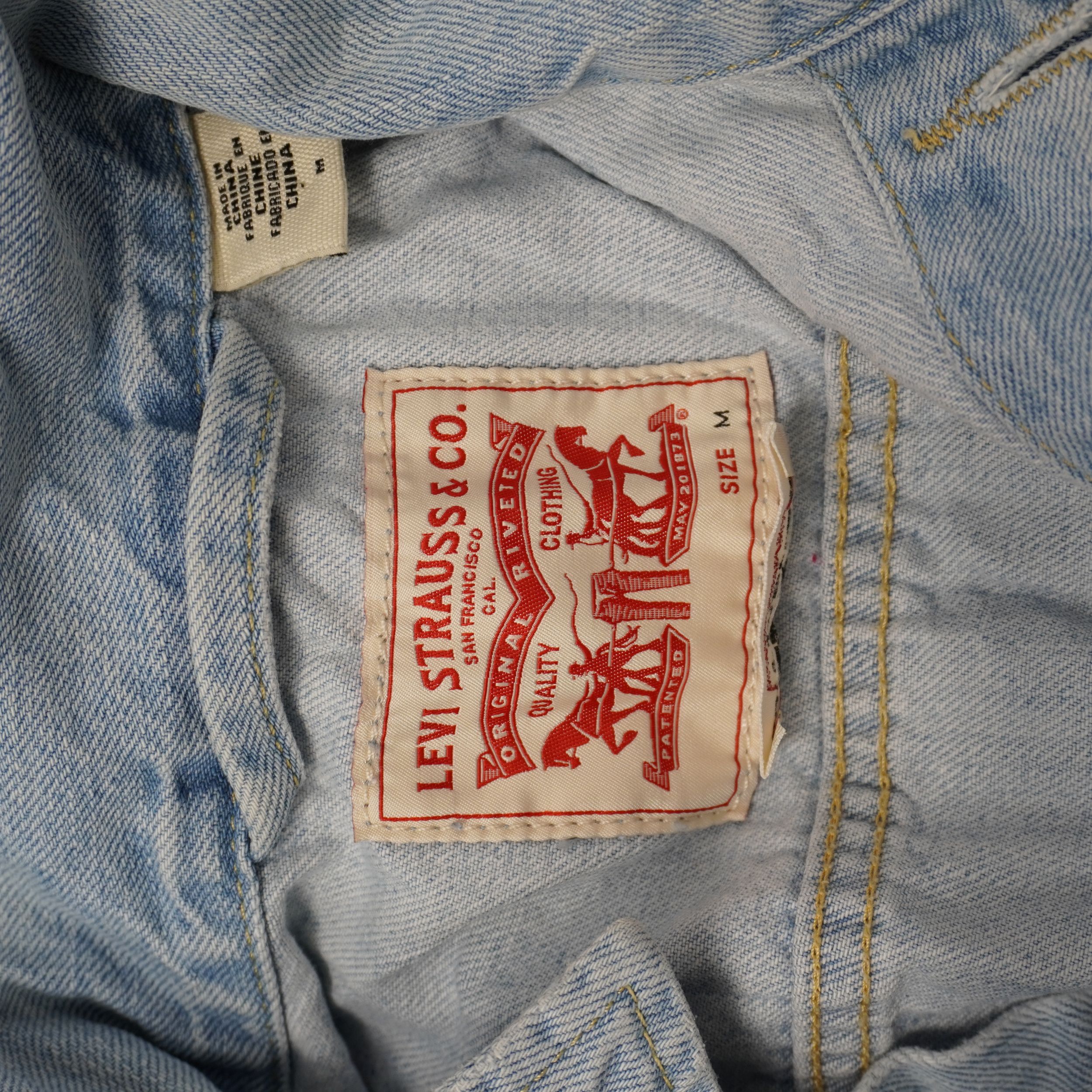 Etichetta interna in tessuto Levi Strauss con logo rosso a due cavalli stampato sul retro del collo