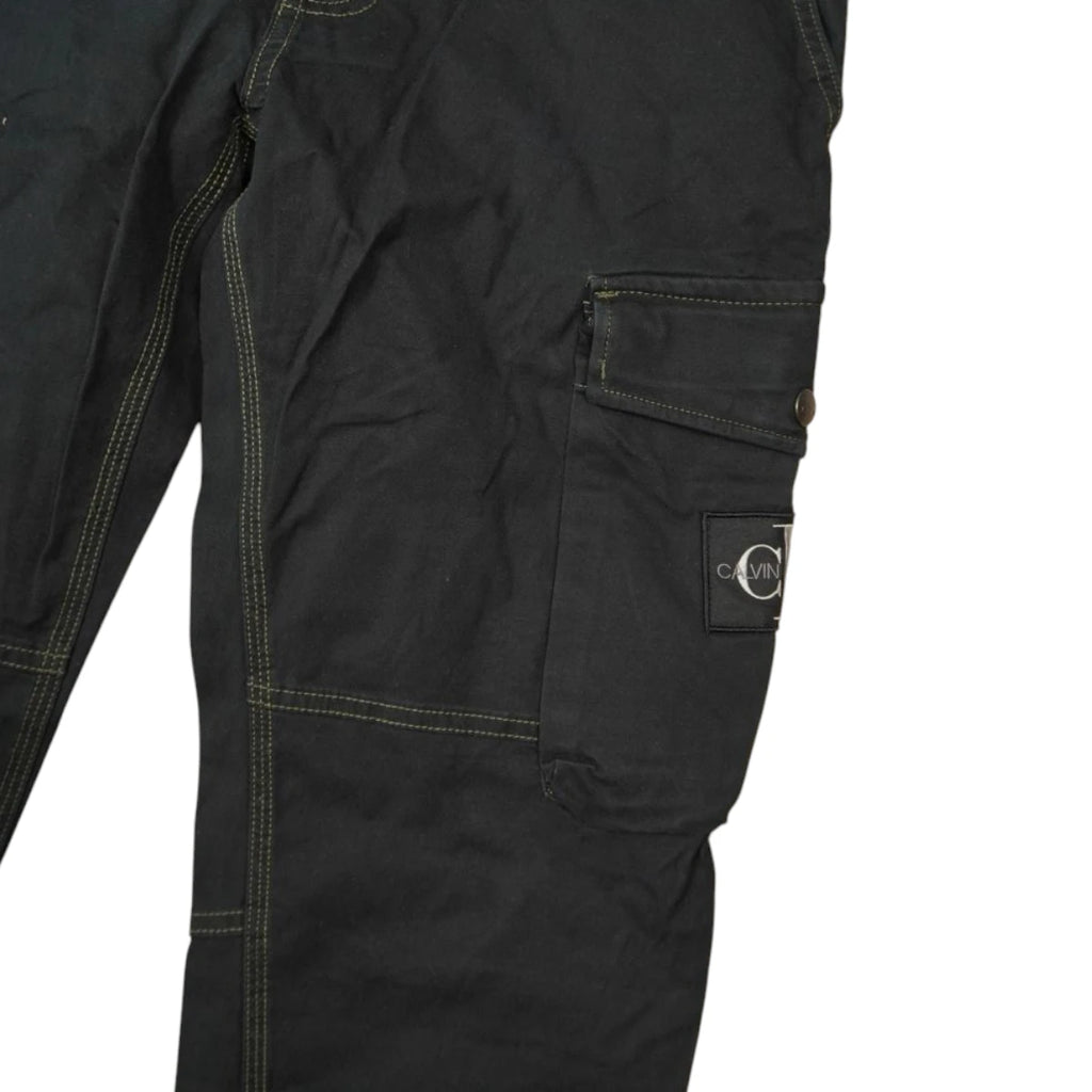Dettaglio macro della tasca cargo laterale sinistra con patch logo rettangolare Calvin Klein Jeans