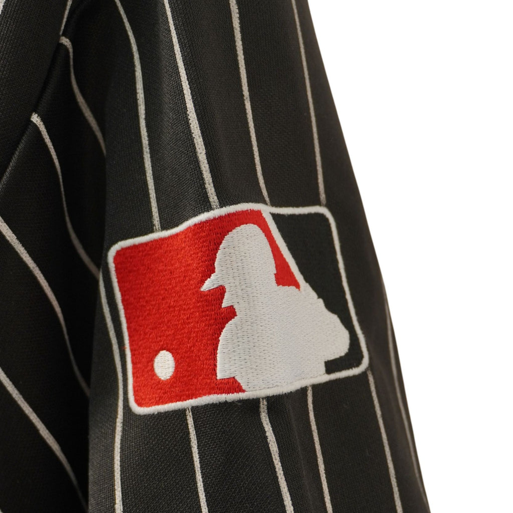 Dettaglio ravvicinato della patch rettangolare rossa con logo ufficiale MLB applicata sulla manica.