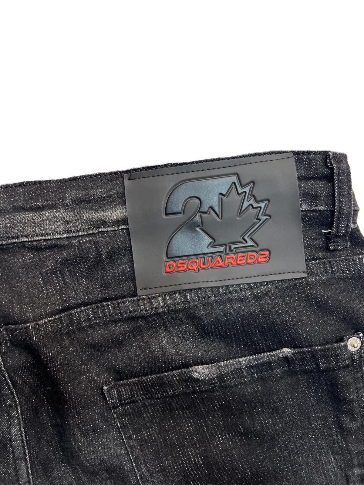 Dettaglio della salpa posteriore in pelle scura con logo impresso sul retro dei jeans Dsquared2.